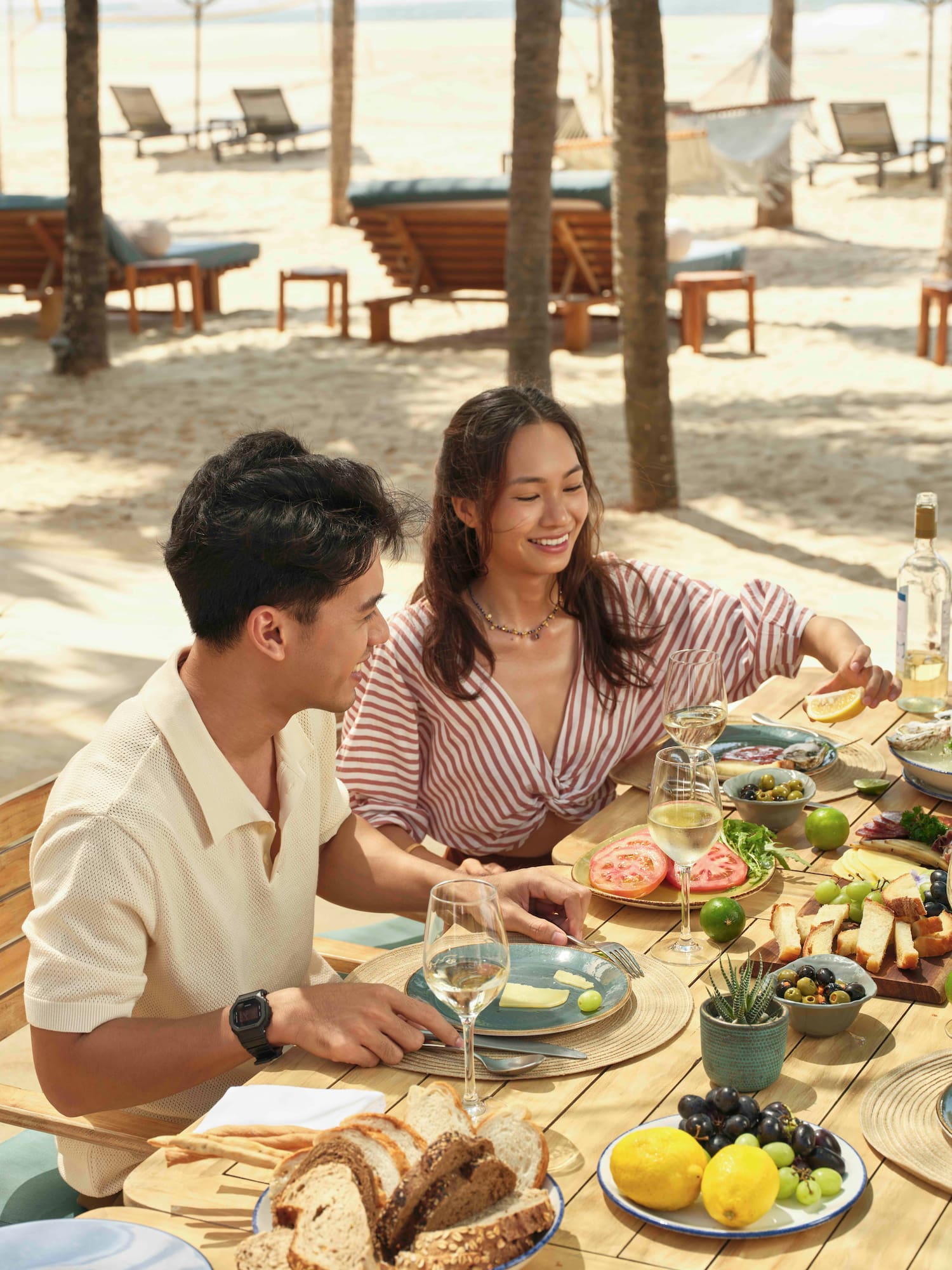 a man and woman sitting at a table with food on it