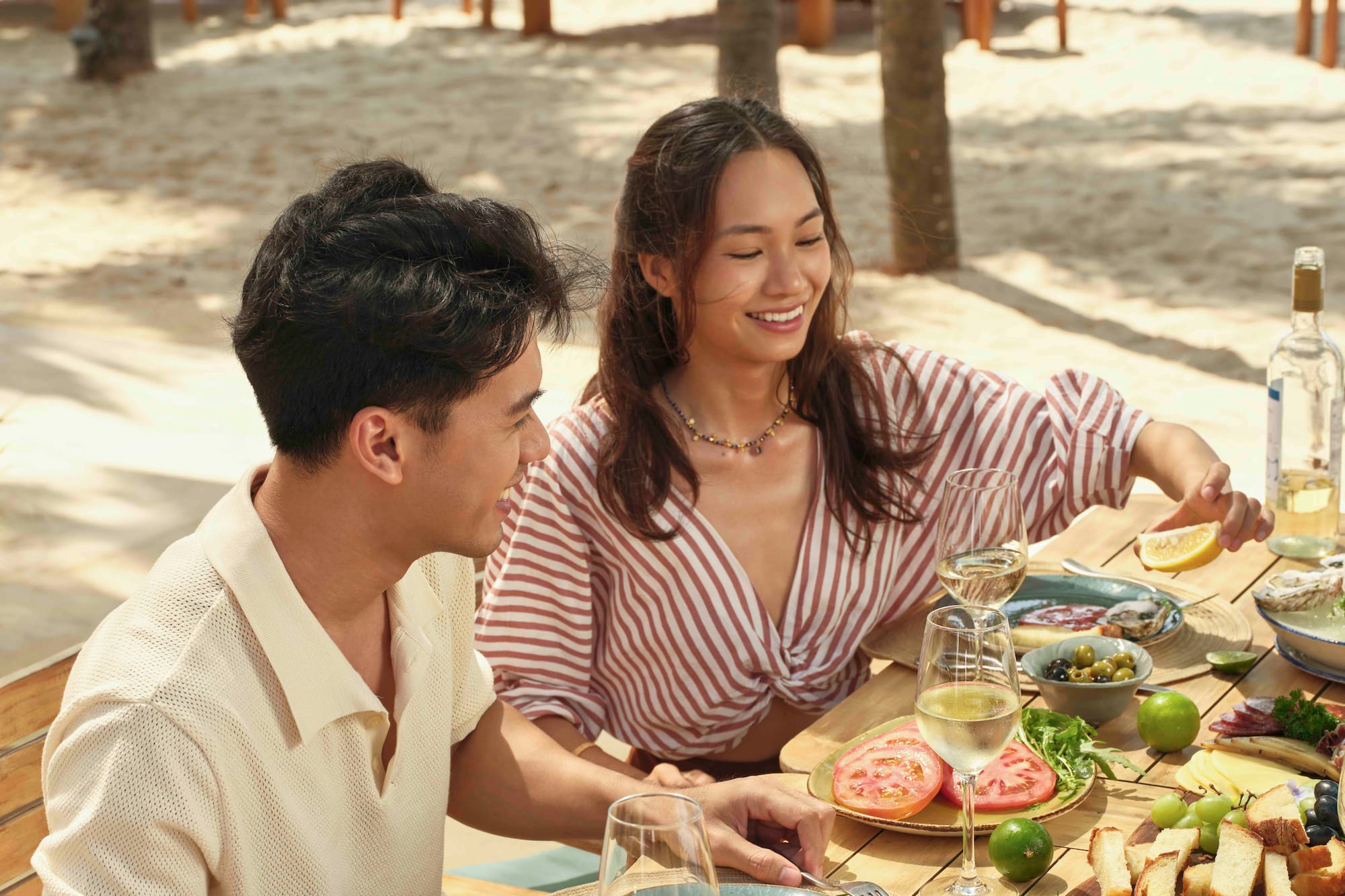 a man and woman sitting at a table with food on it