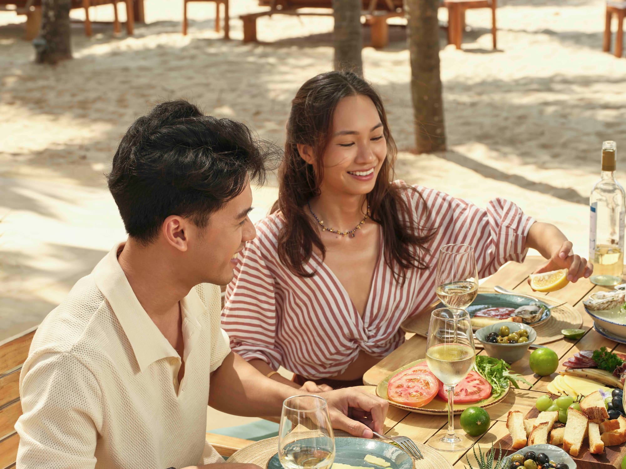 a man and woman sitting at a table with food on it