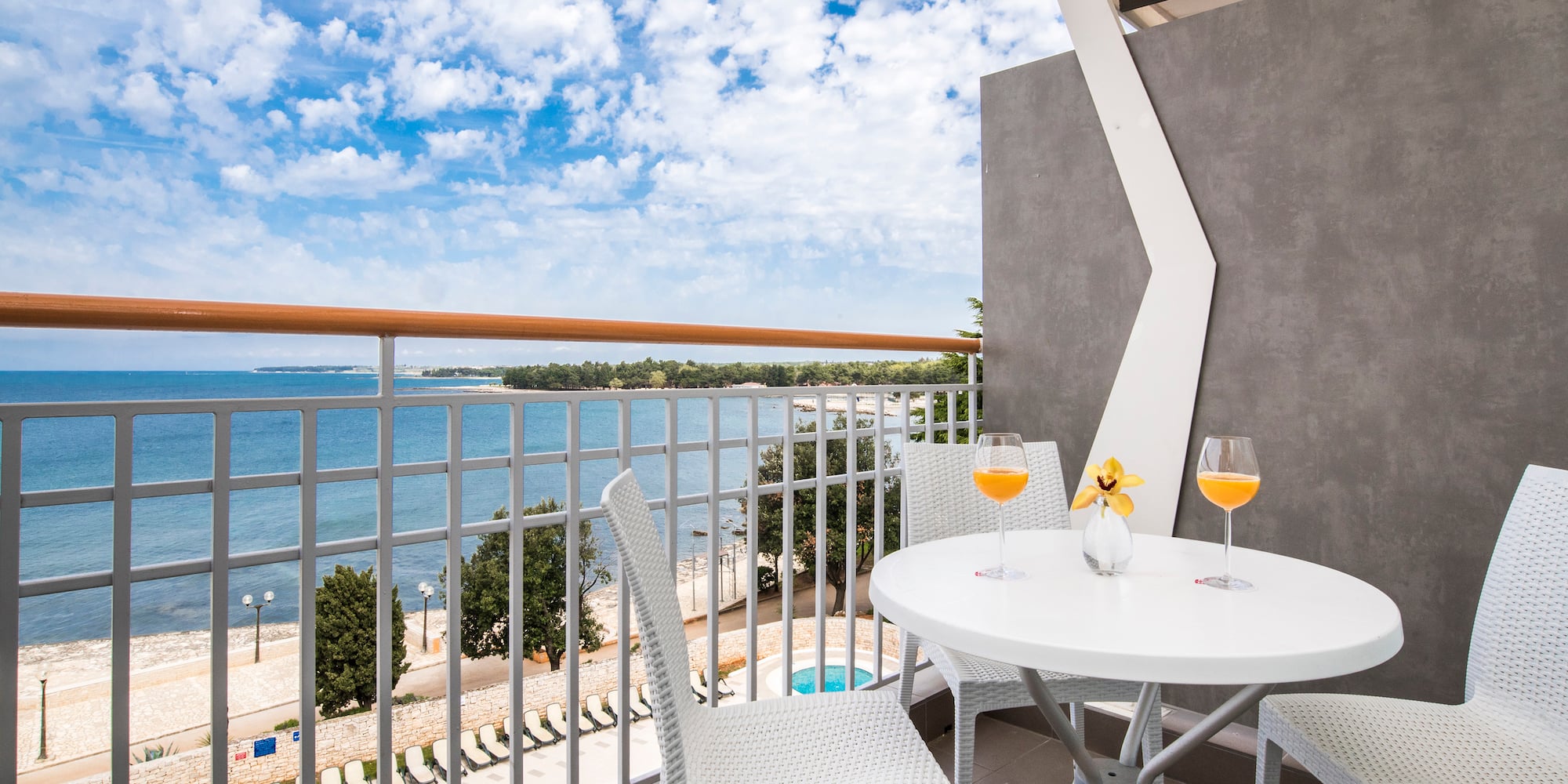 a table and chairs on a balcony overlooking a body of water