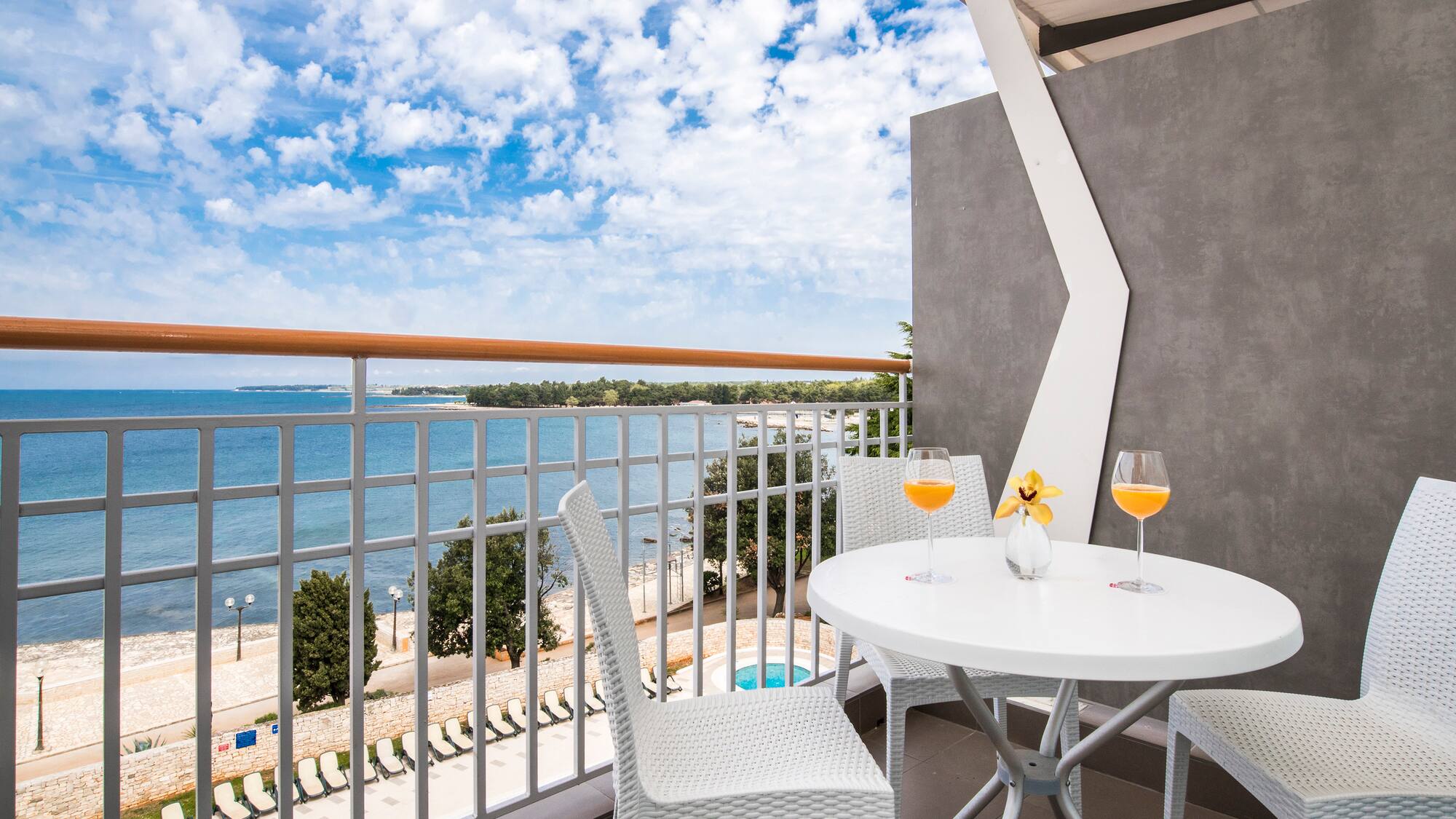 a table and chairs on a balcony overlooking a body of water