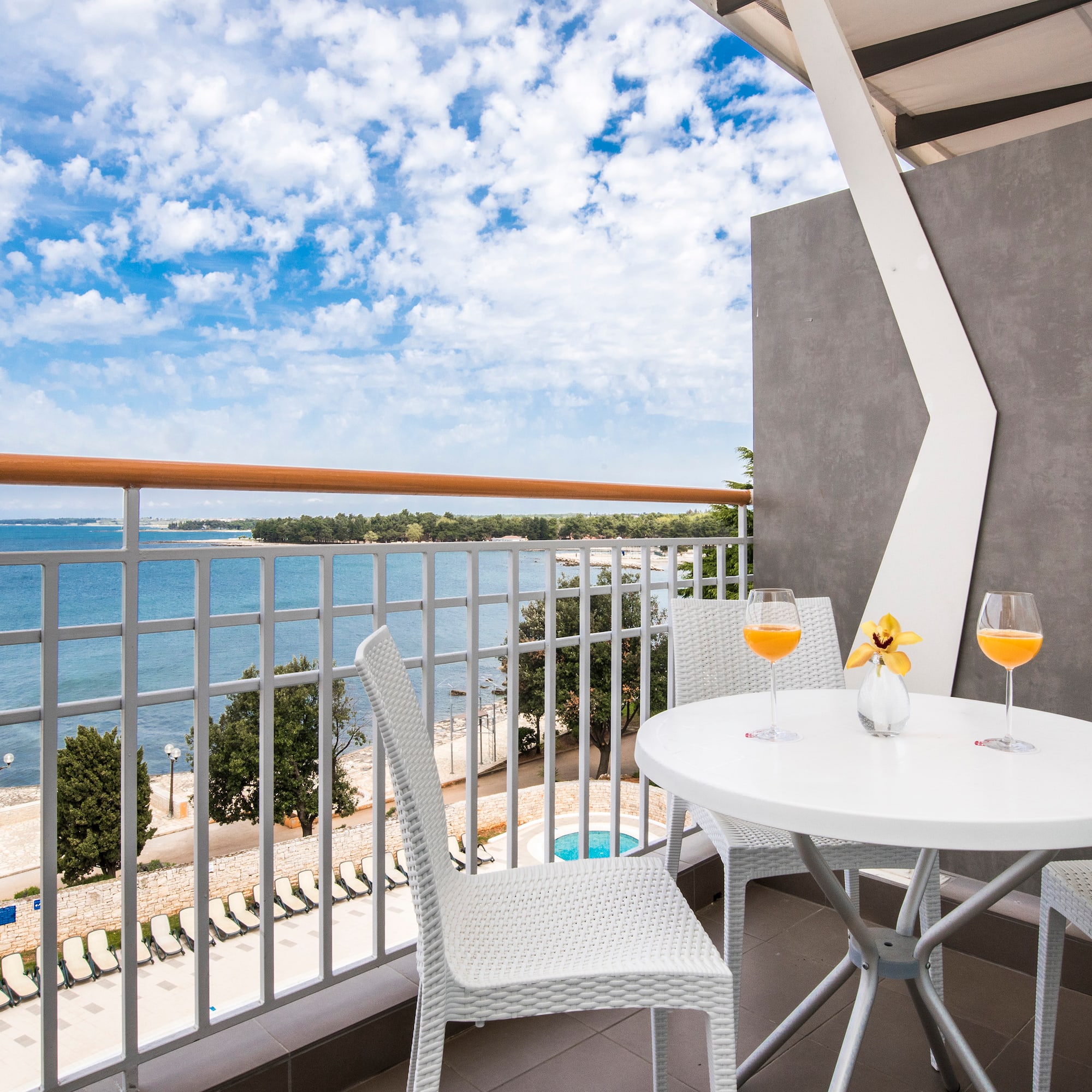 a table and chairs on a balcony overlooking a body of water