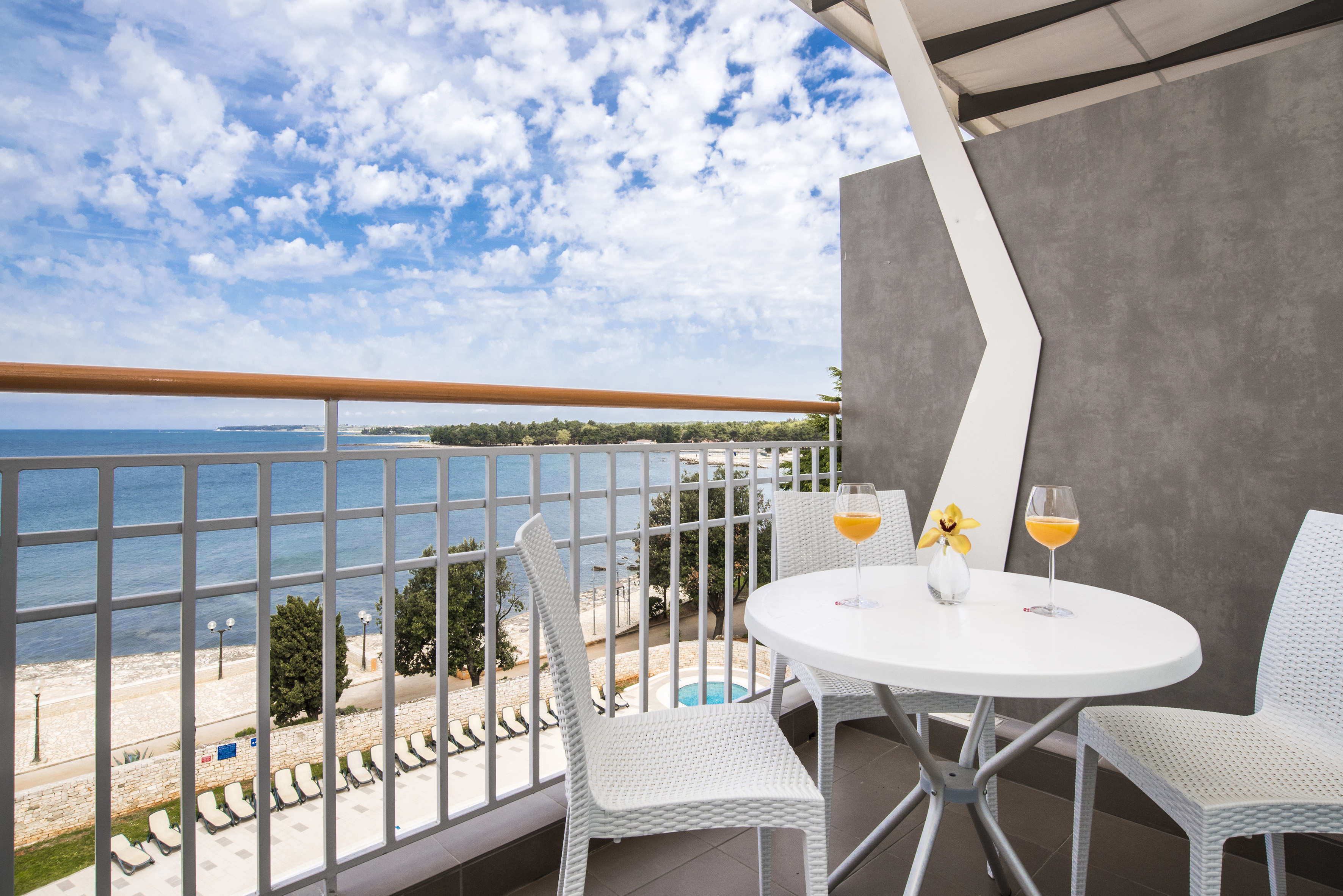 a table and chairs on a balcony overlooking a body of water