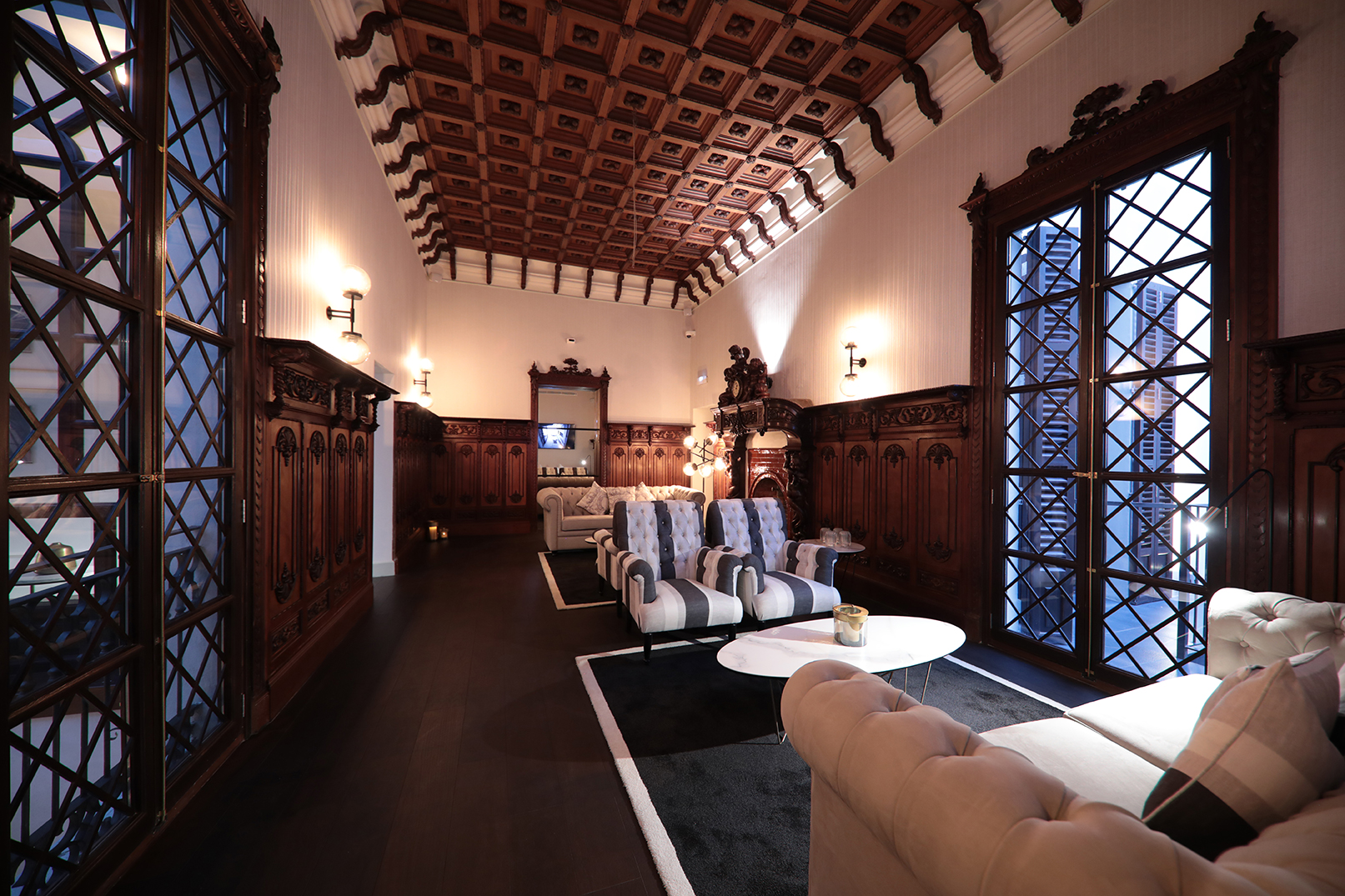Grand hotel lobby with ornate wood ceiling, rich paneling, and elegant furnishings.