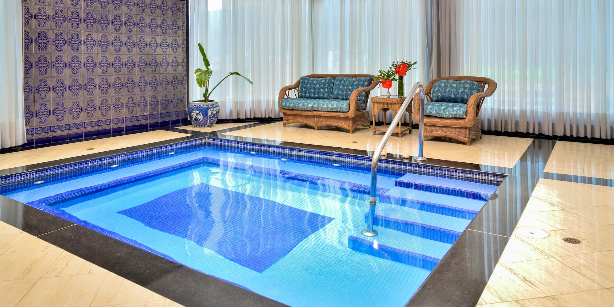 a indoor swimming pool with chairs and a couch