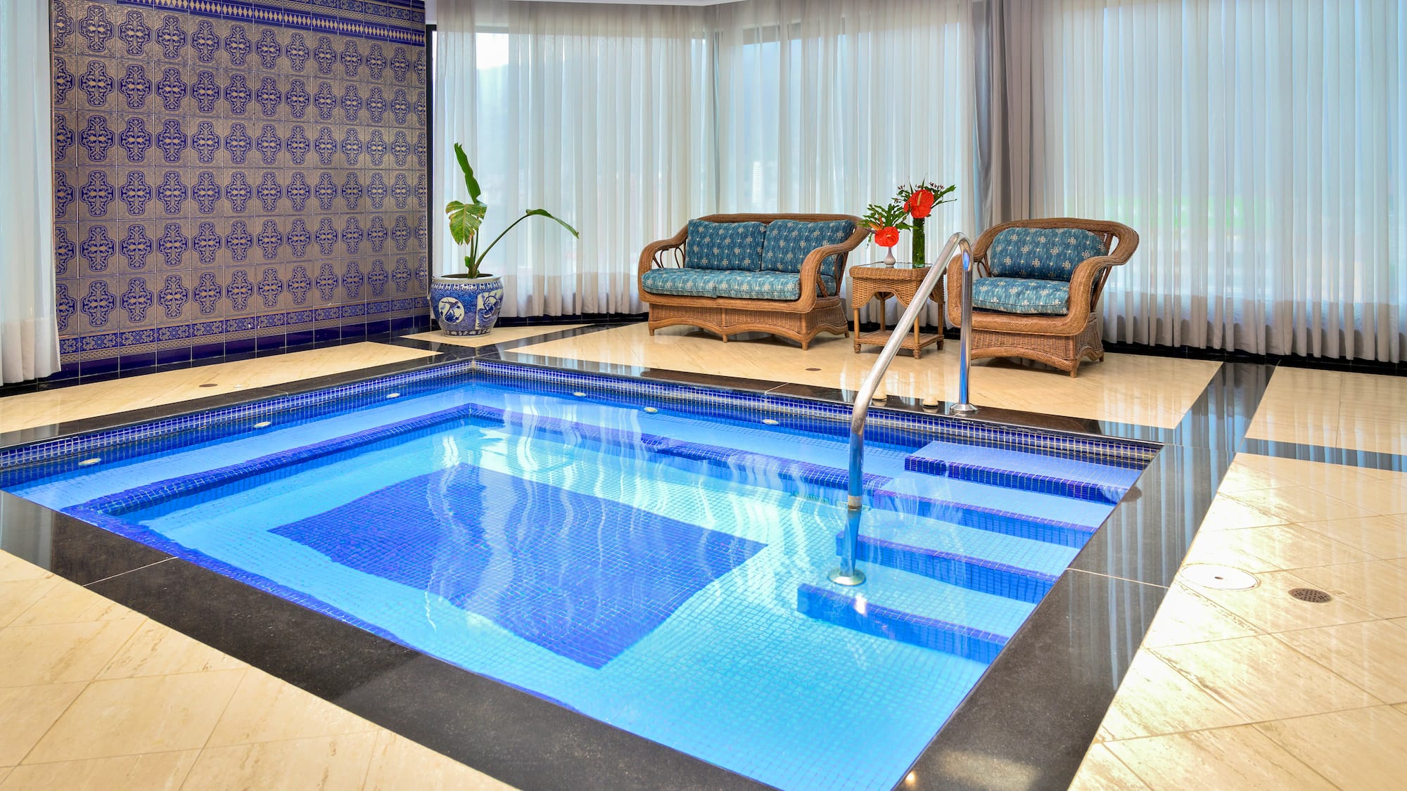 a indoor swimming pool with chairs and a couch