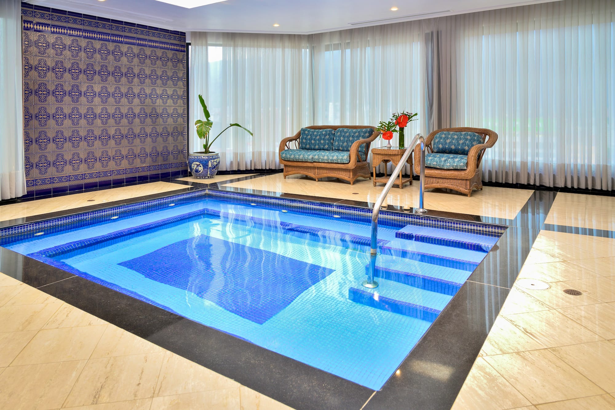 a indoor swimming pool with chairs and a couch