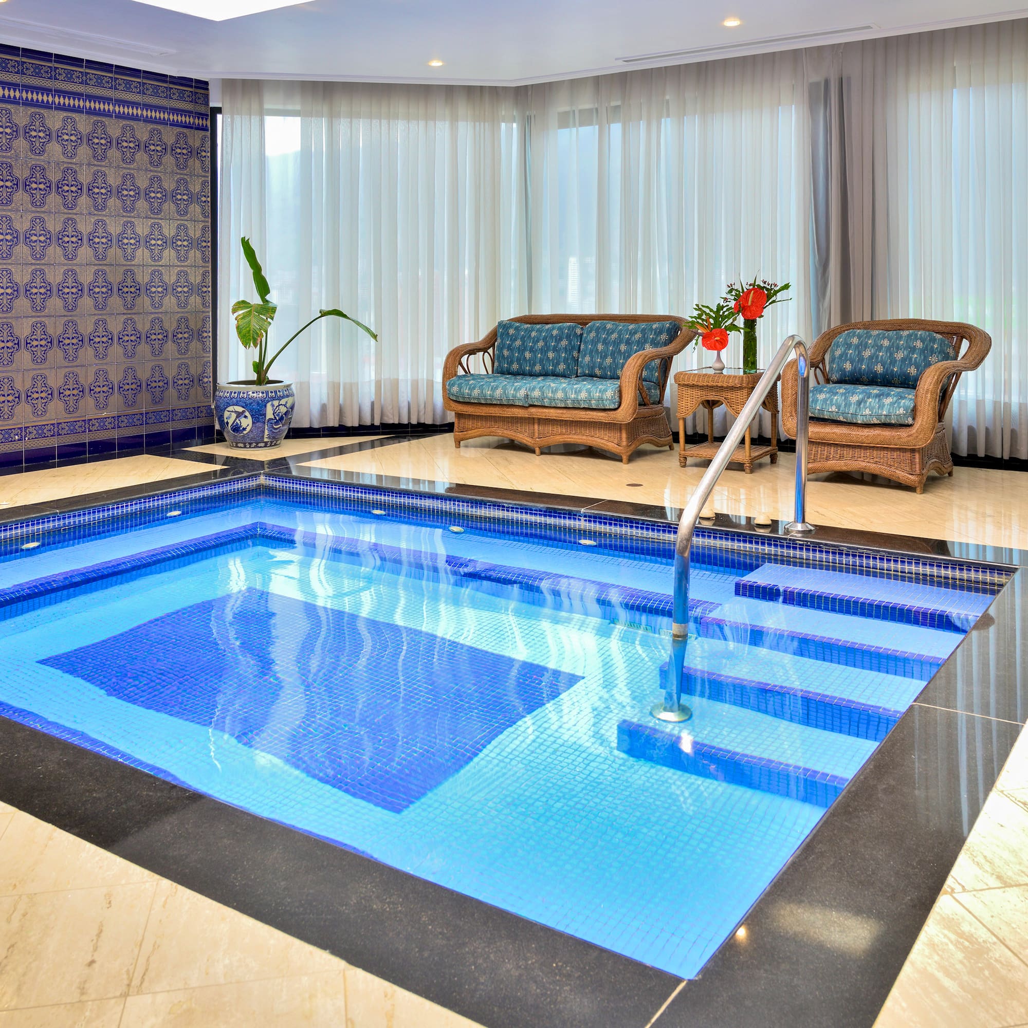a indoor swimming pool with chairs and a couch