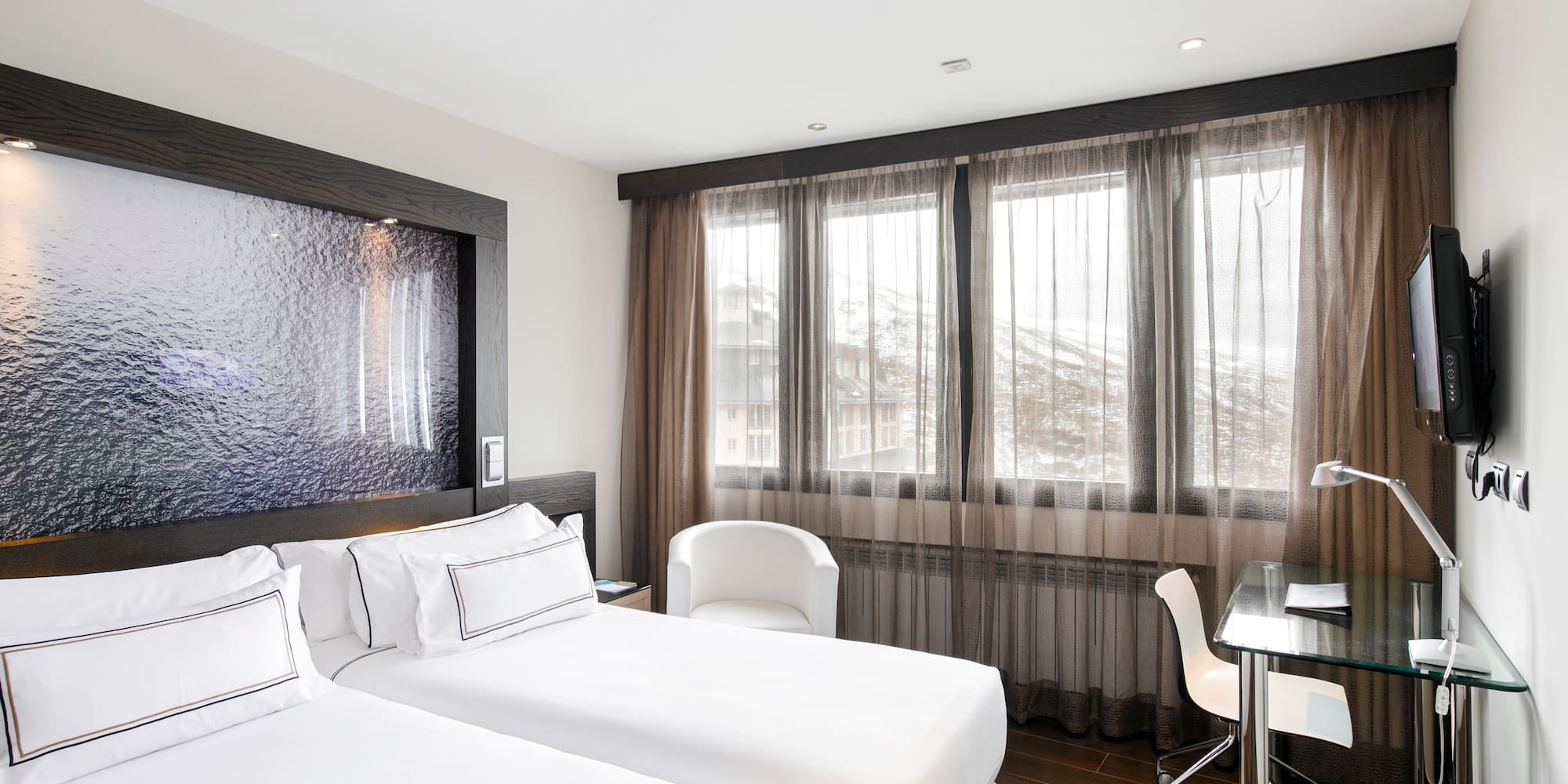 a room with two beds and a desk