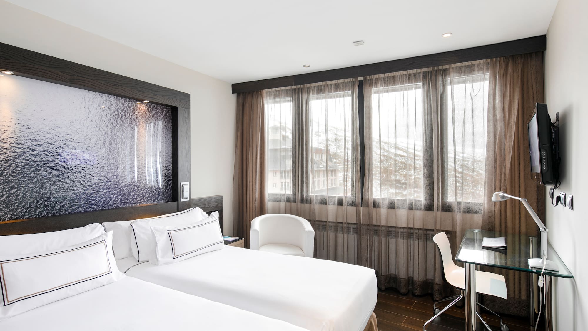 a room with two beds and a desk