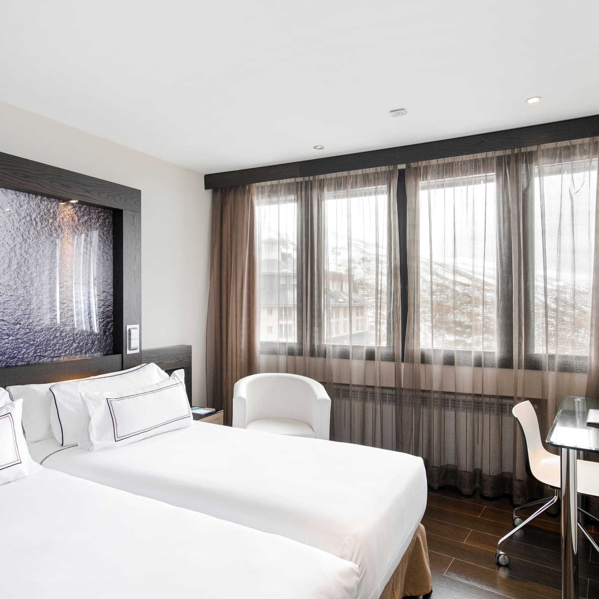 a room with two beds and a desk