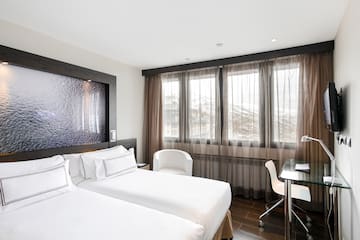 a room with two beds and a desk