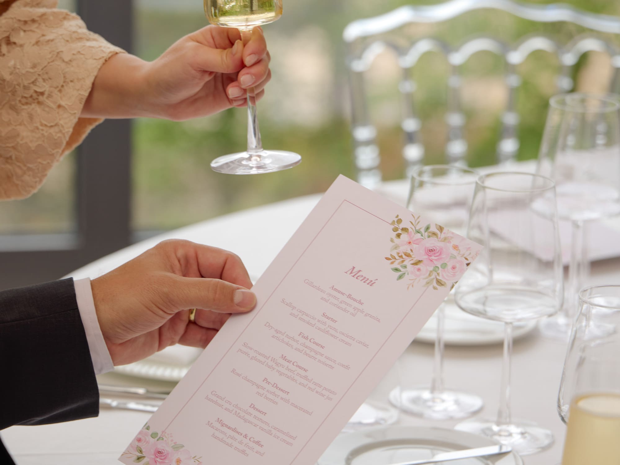 Guest holding champagne while reading a gourmet menu at a fine dining event.