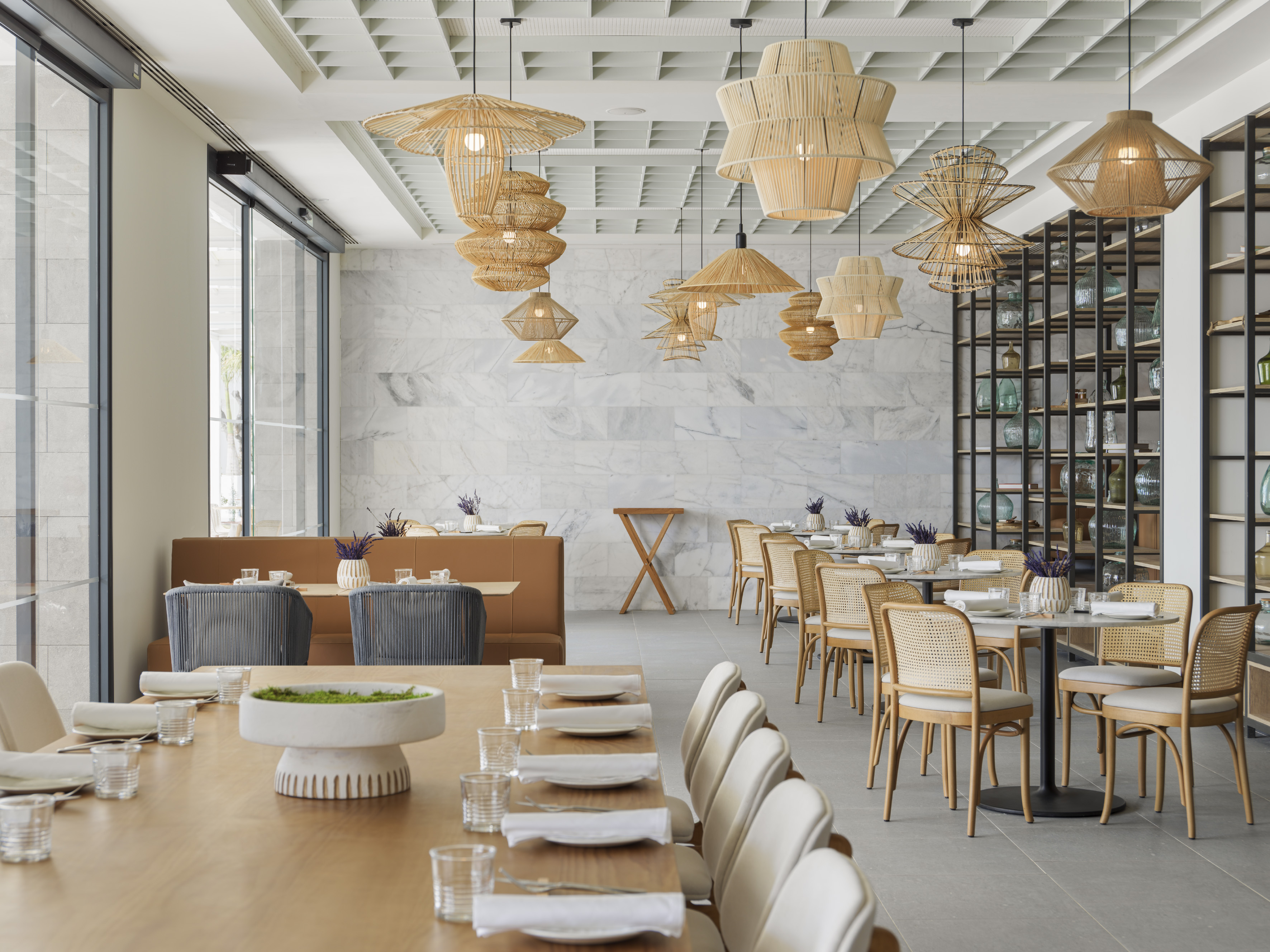 Modern restaurant with natural rattan lights, marble walls, and wood tables.