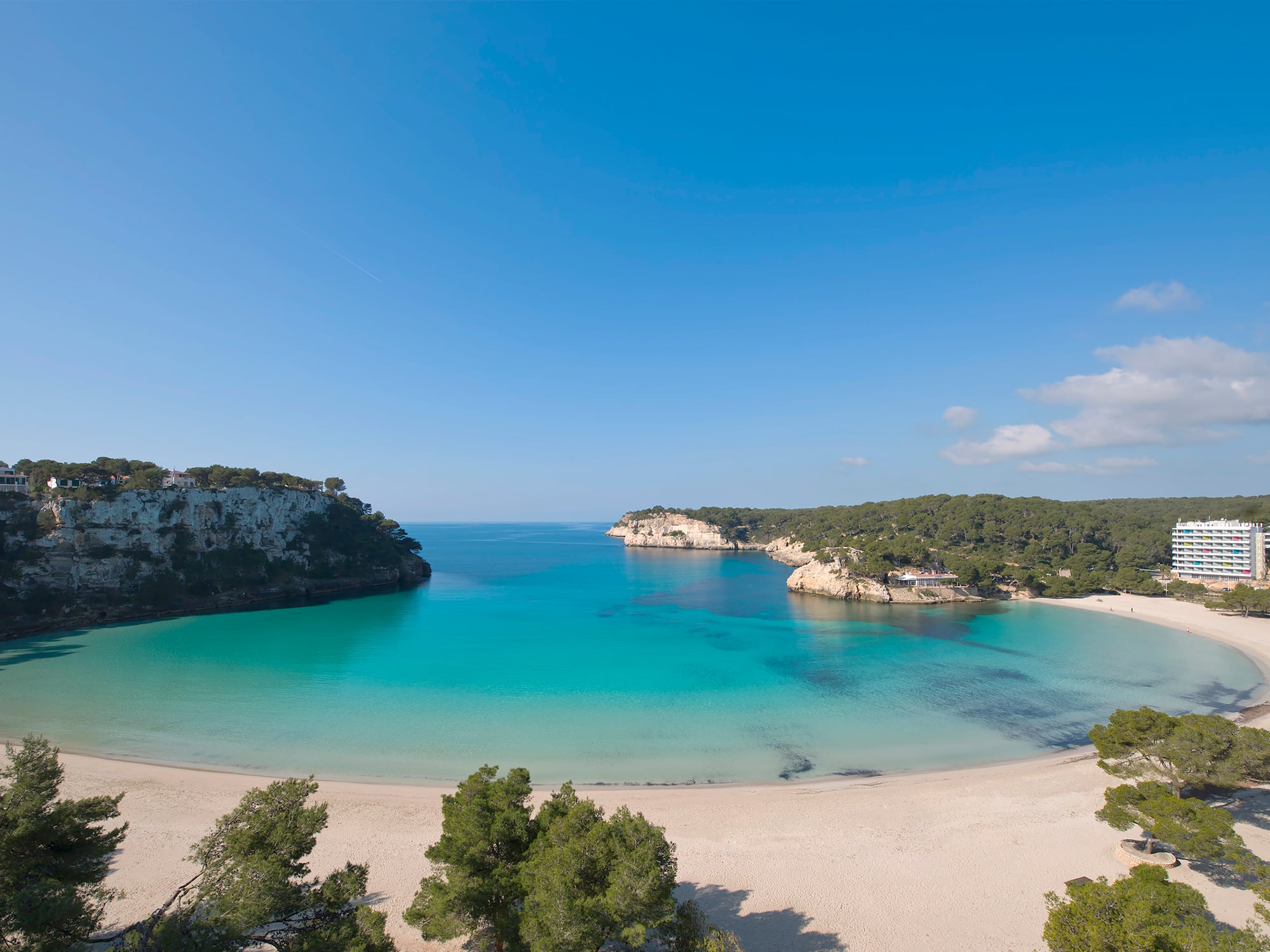 Cala Galdana beach, Menorca: turquoise water, white sand, cliffs, resort.