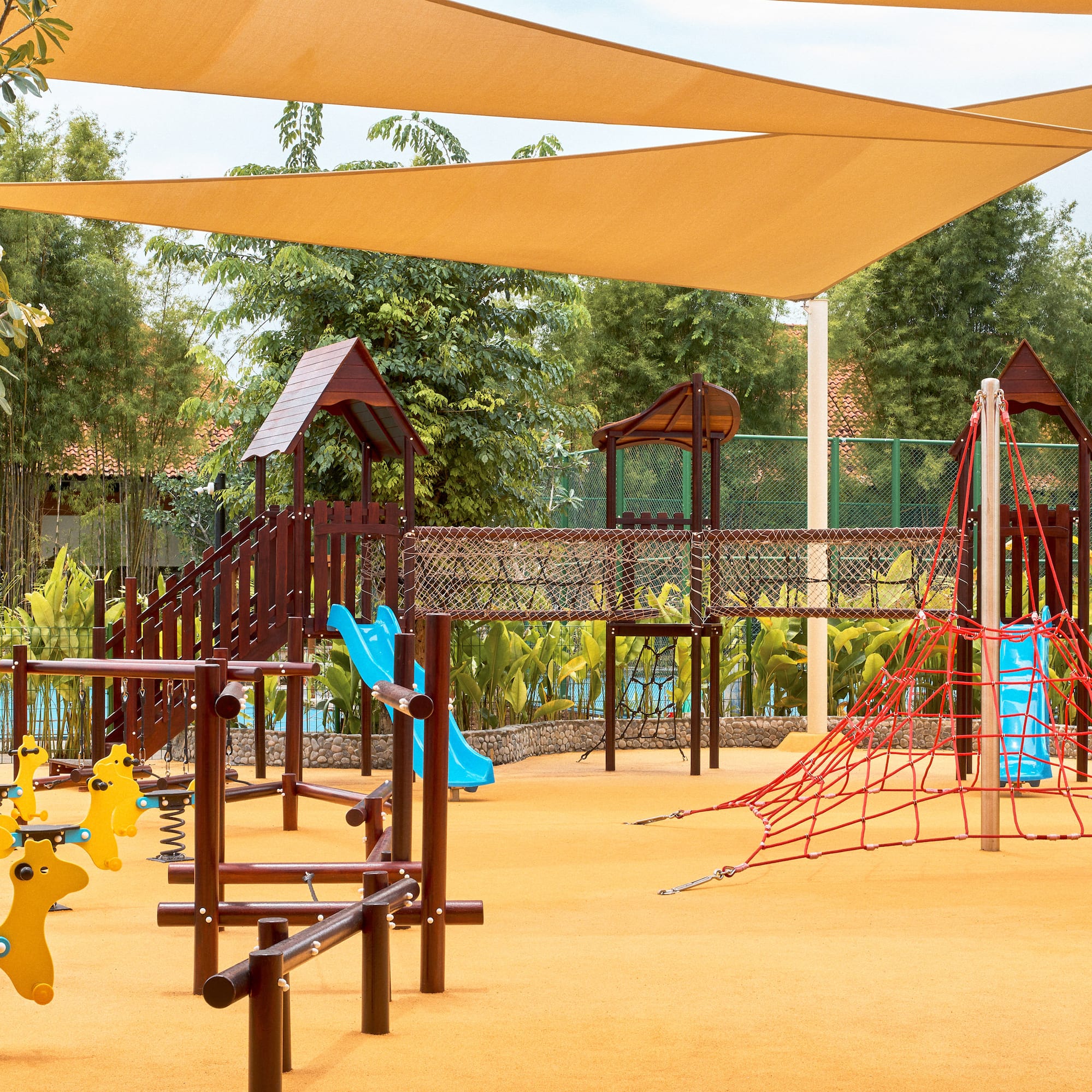 a playground with a net and yellow toys