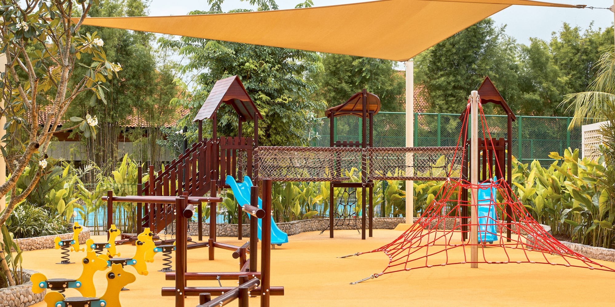 a playground with a net and yellow toys