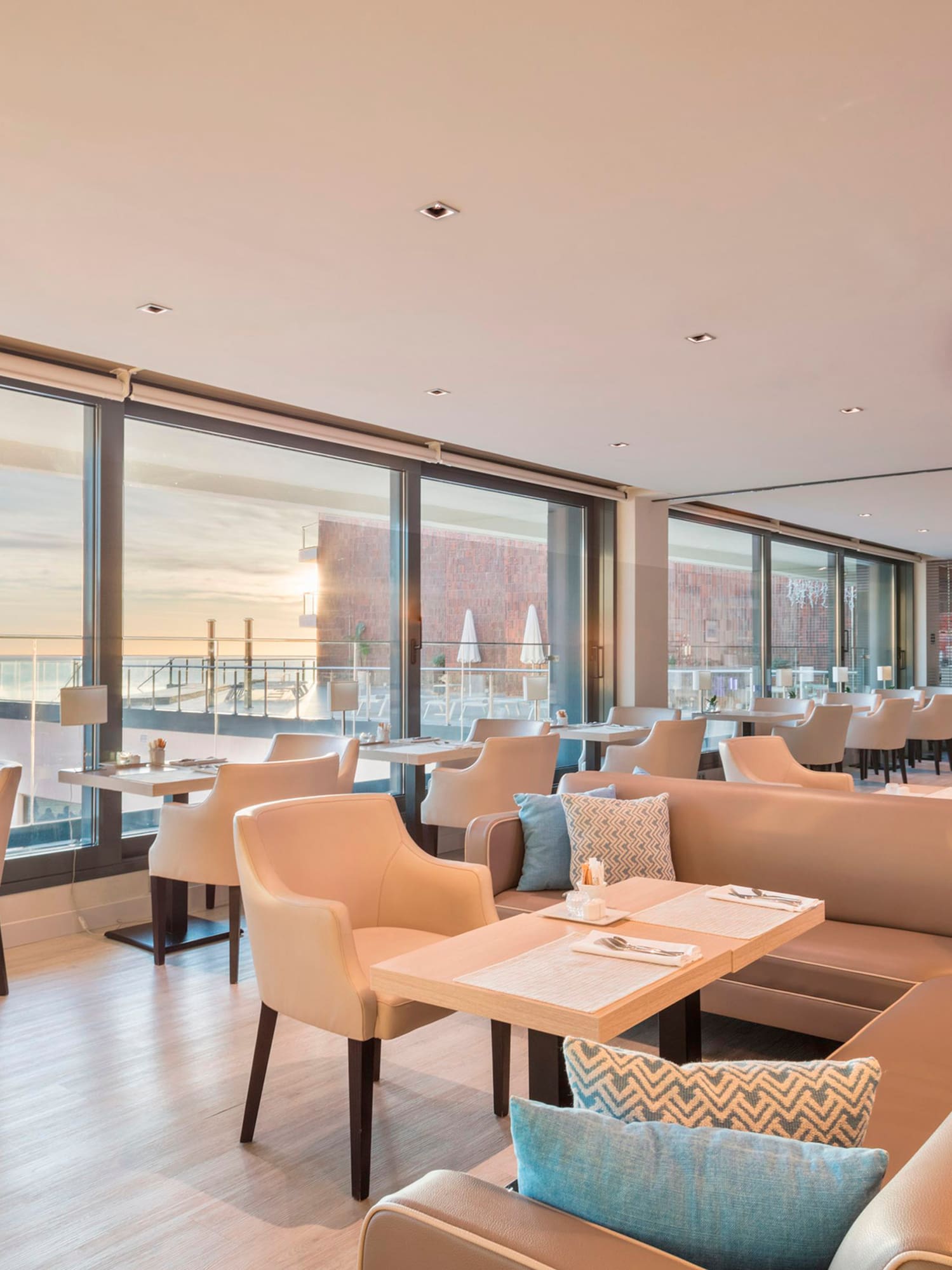 a room with a large window and a large couch and tables