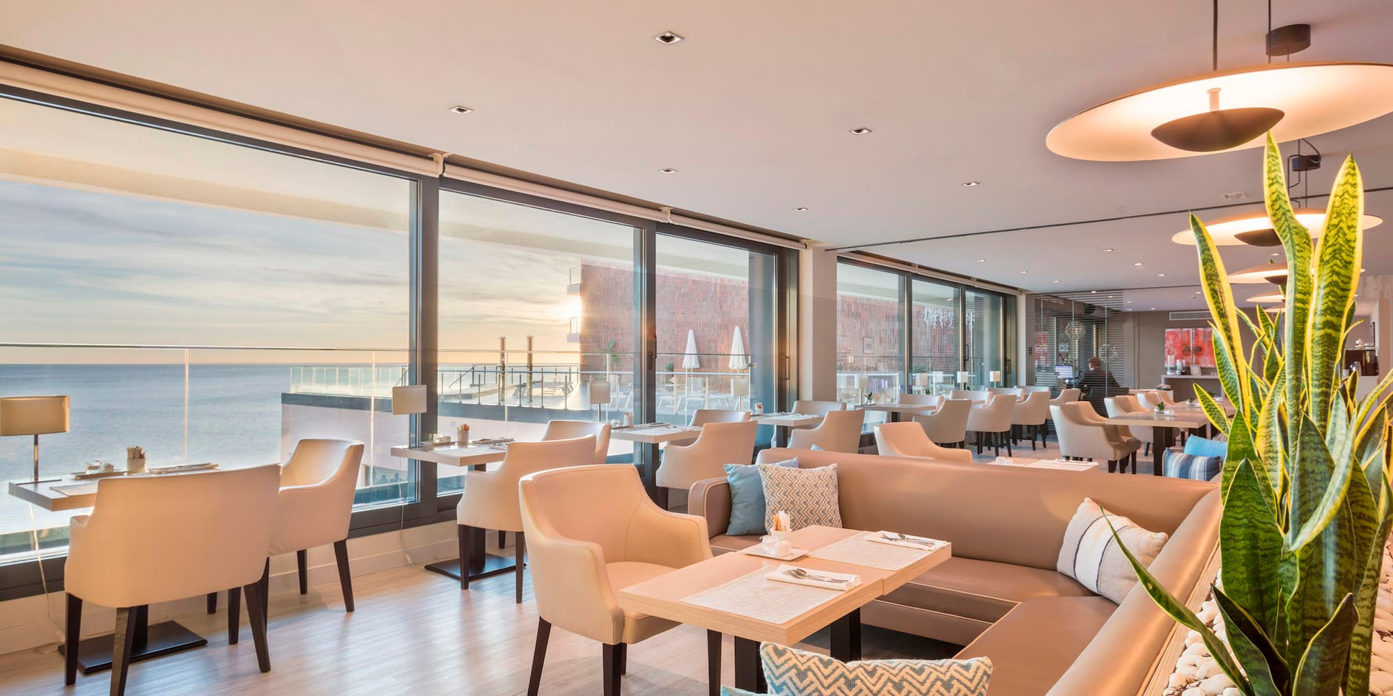 a room with a large window and tables and chairs