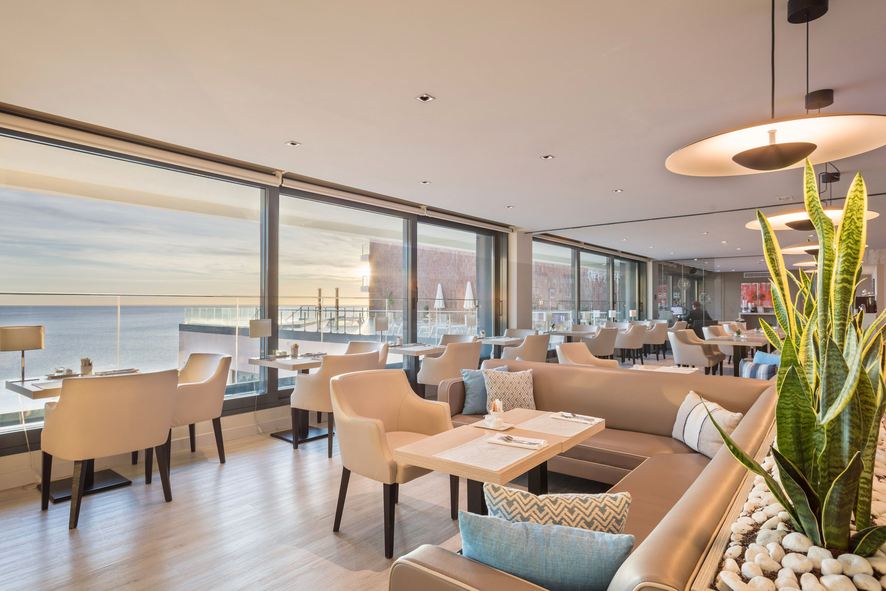 a room with a large window and tables and chairs