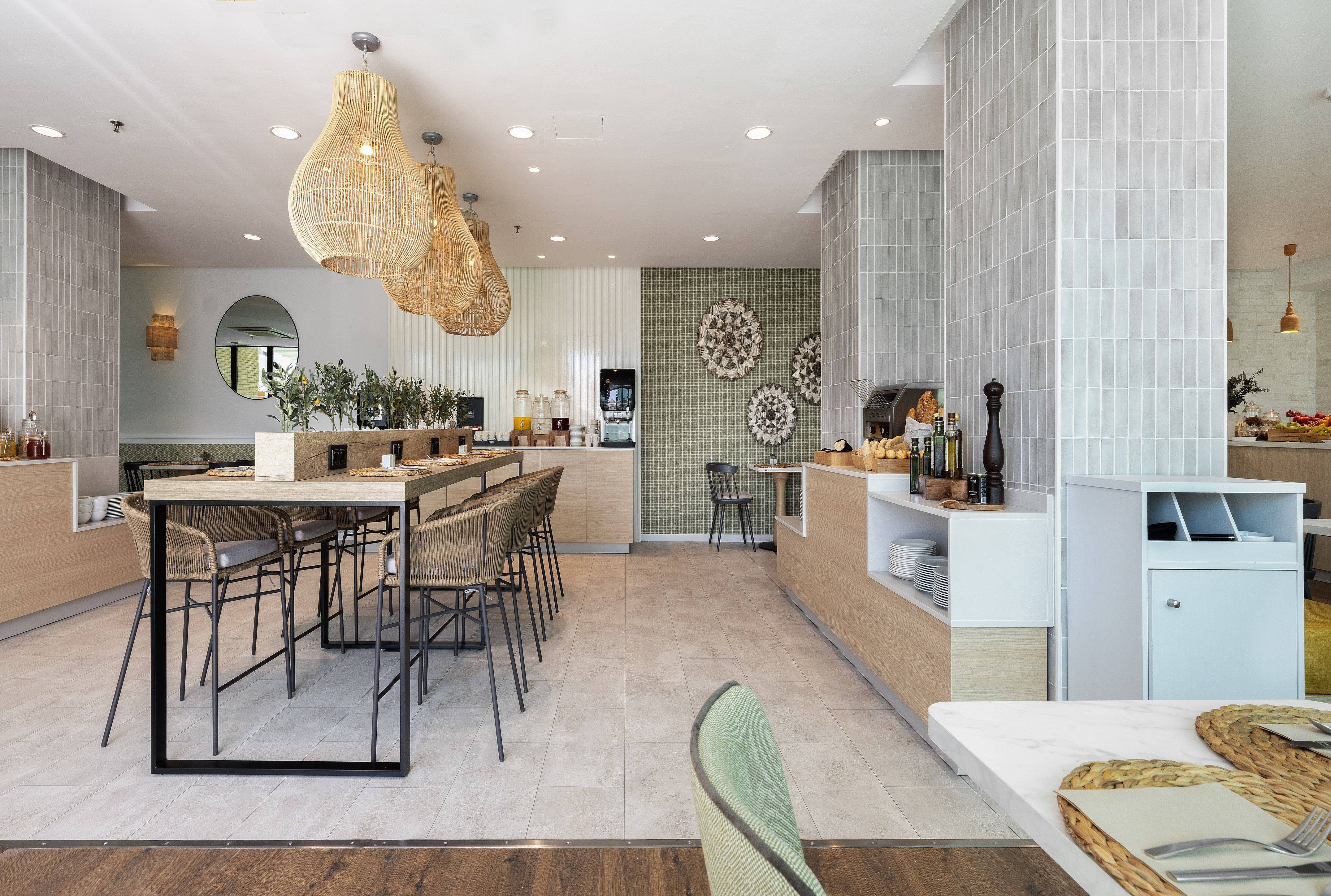 Stylish dining area with buffet, long table, rattan lamps, and tiled walls.
