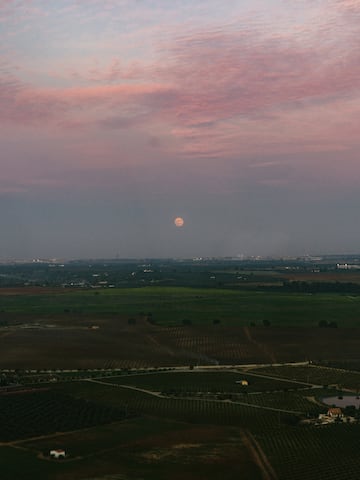 a landscape with a moon in the sky