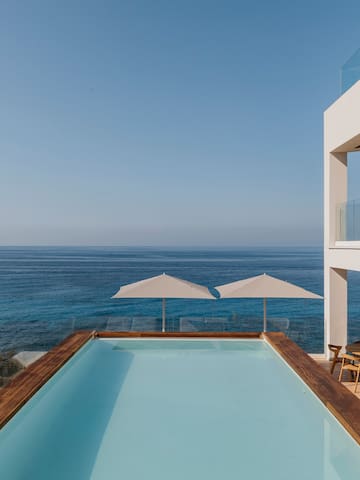 a pool with a deck overlooking the ocean
