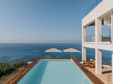 a pool with a deck overlooking the ocean