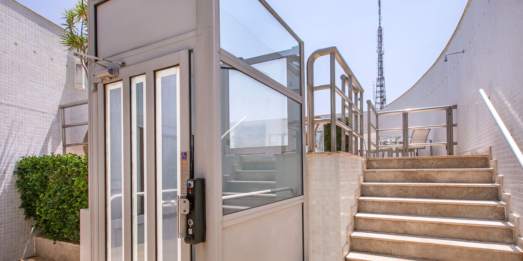 a lift with glass doors and stairs