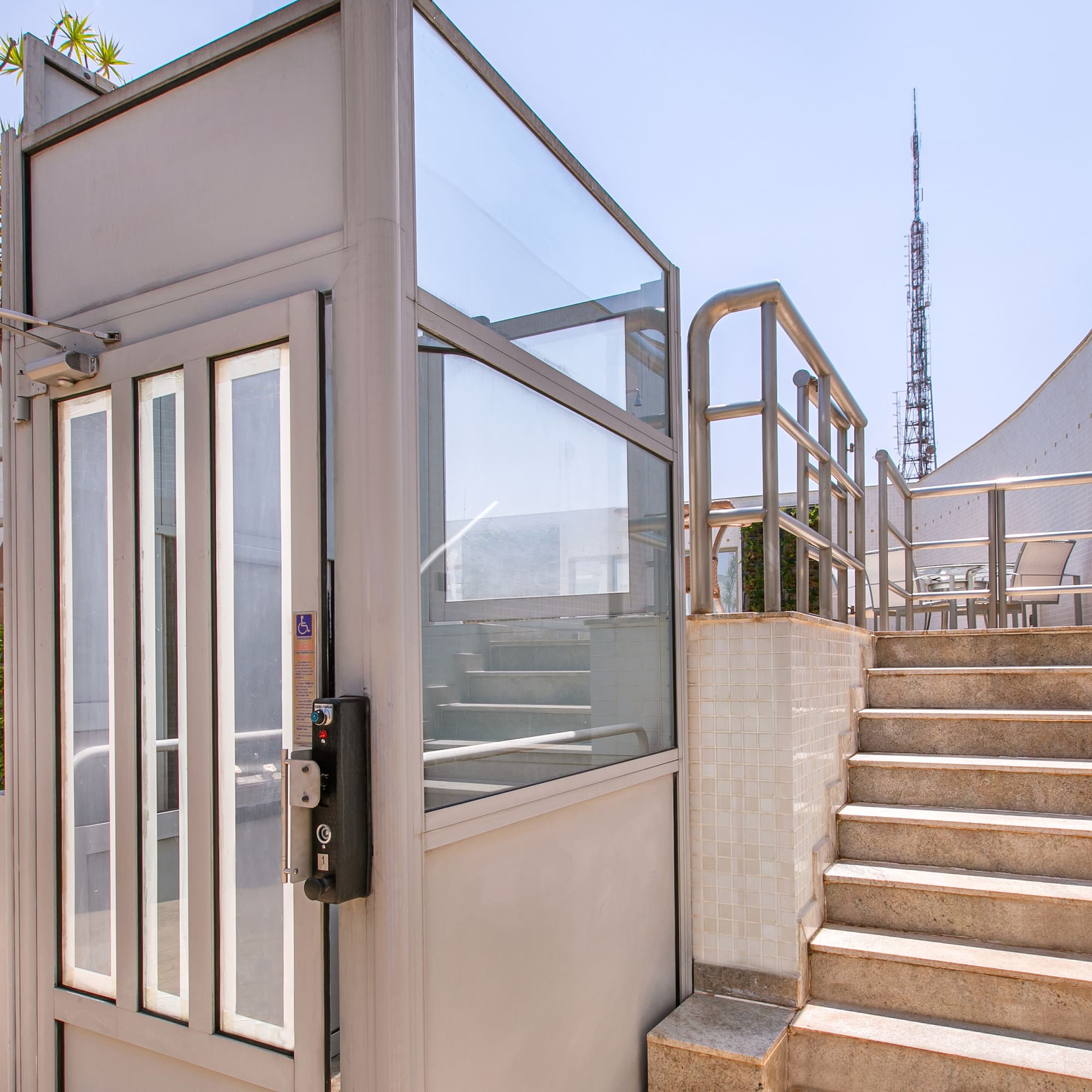 a lift with glass doors and stairs