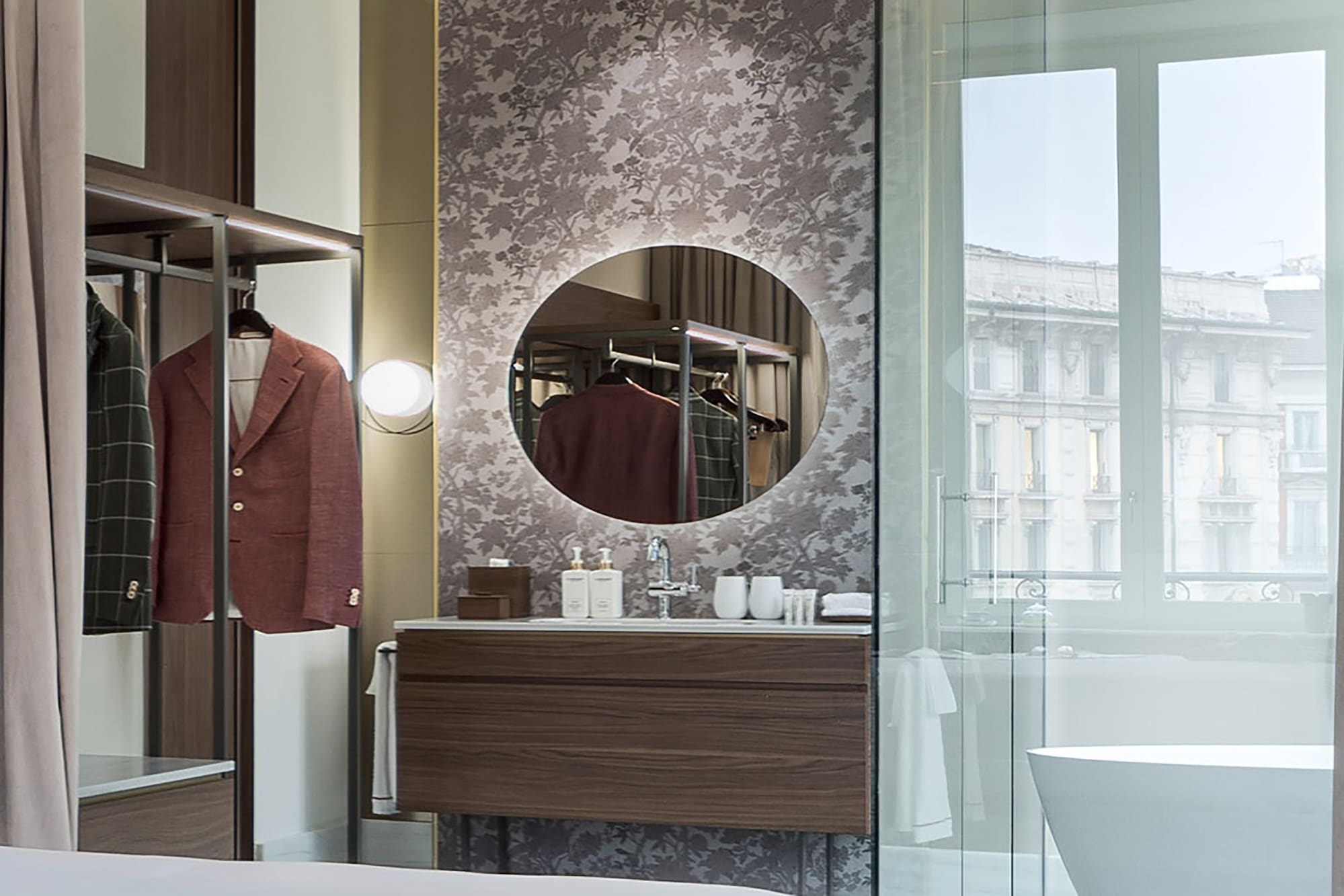 a bathroom with a mirror and a coat on a swinger