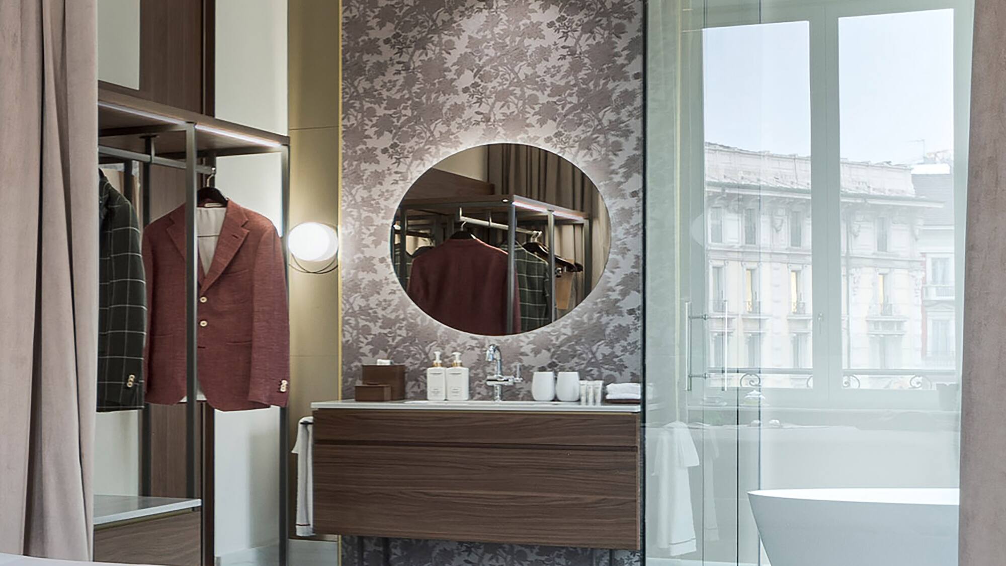 a bathroom with a mirror and a coat on a swinger