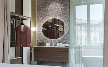 a bathroom with a mirror and a coat on a swinger