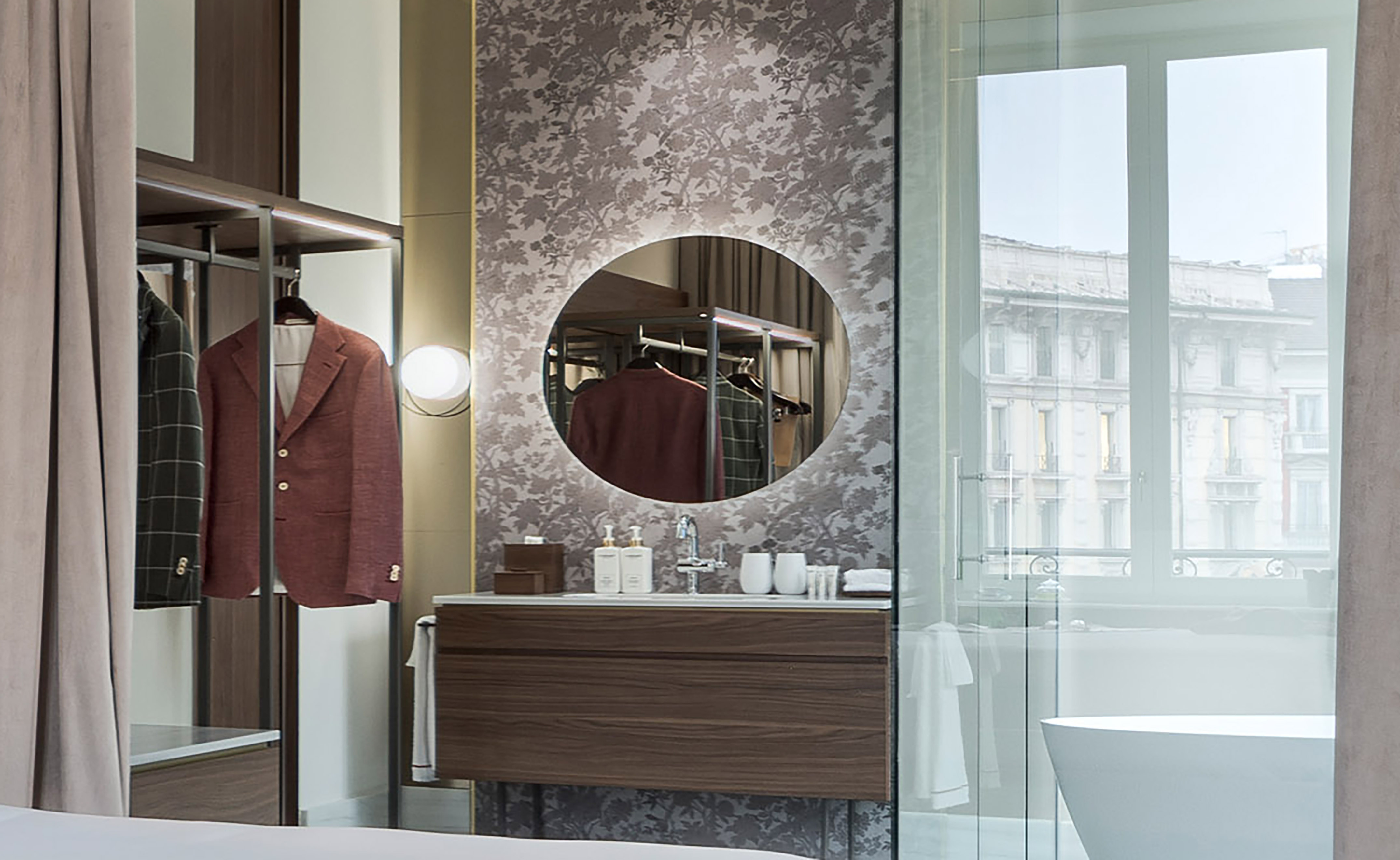 a bathroom with a mirror and a coat on a swinger