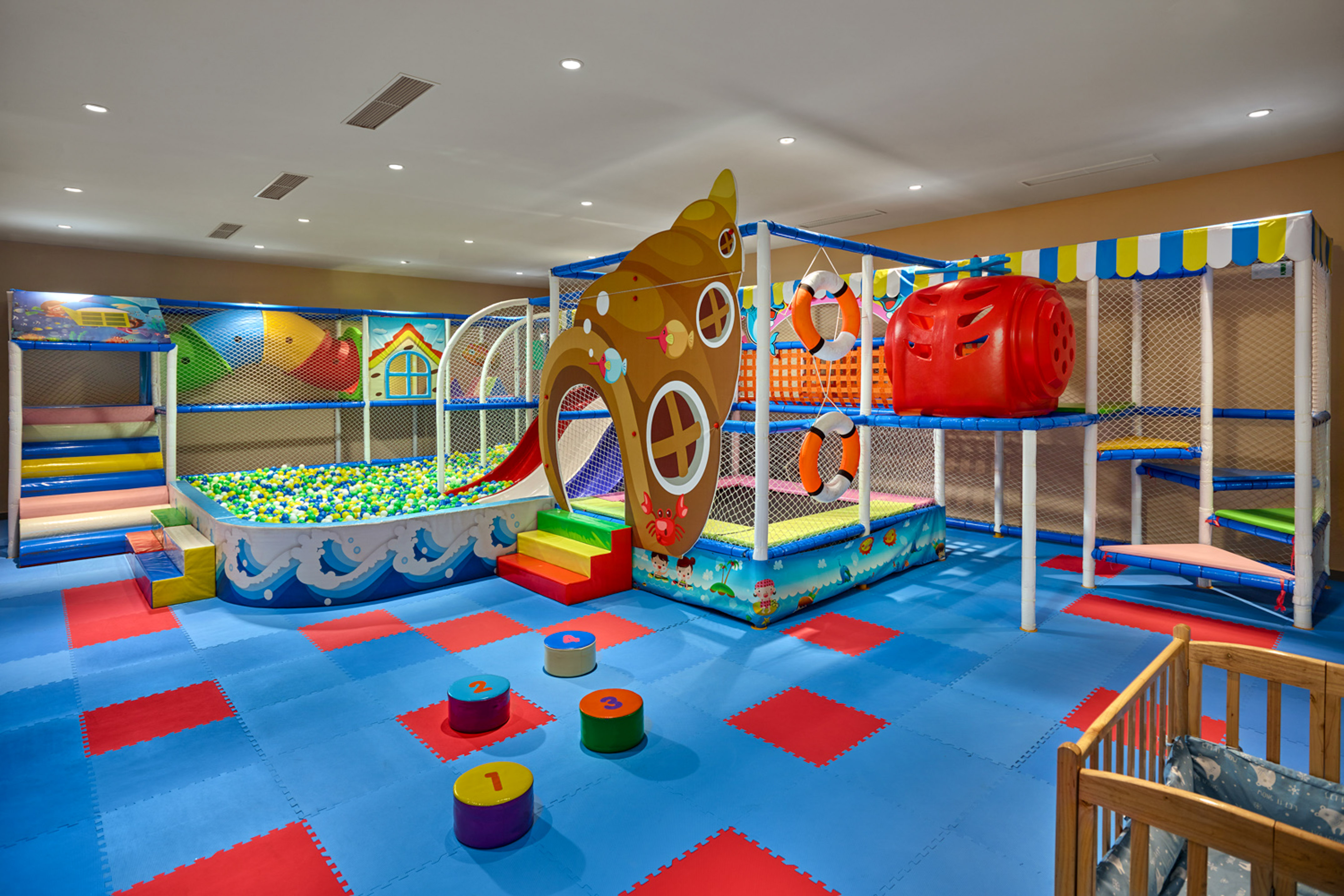 Colorful indoor children's play area with ball pit and soft structures.