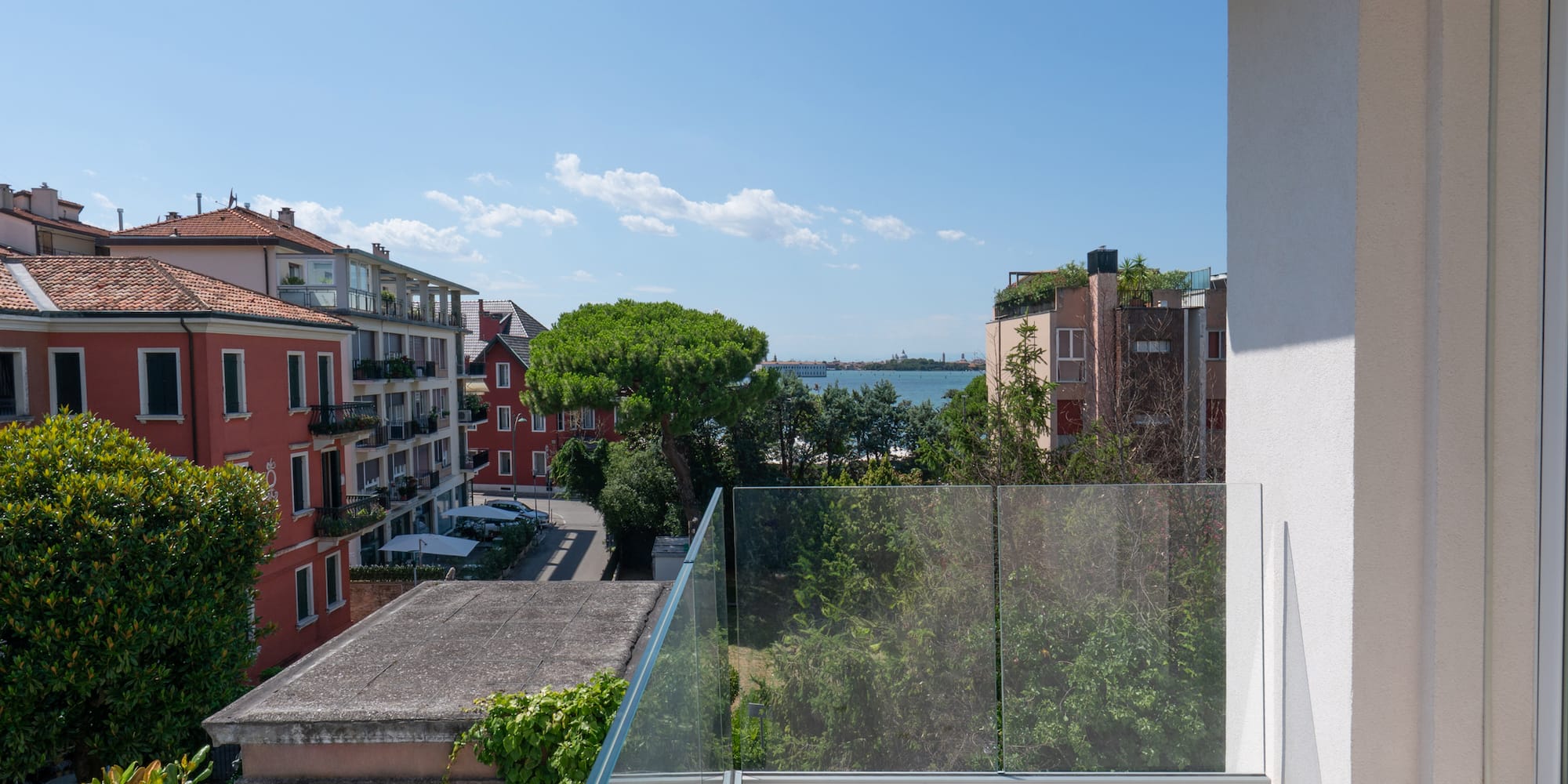 a balcony with a glass railing overlooking a city