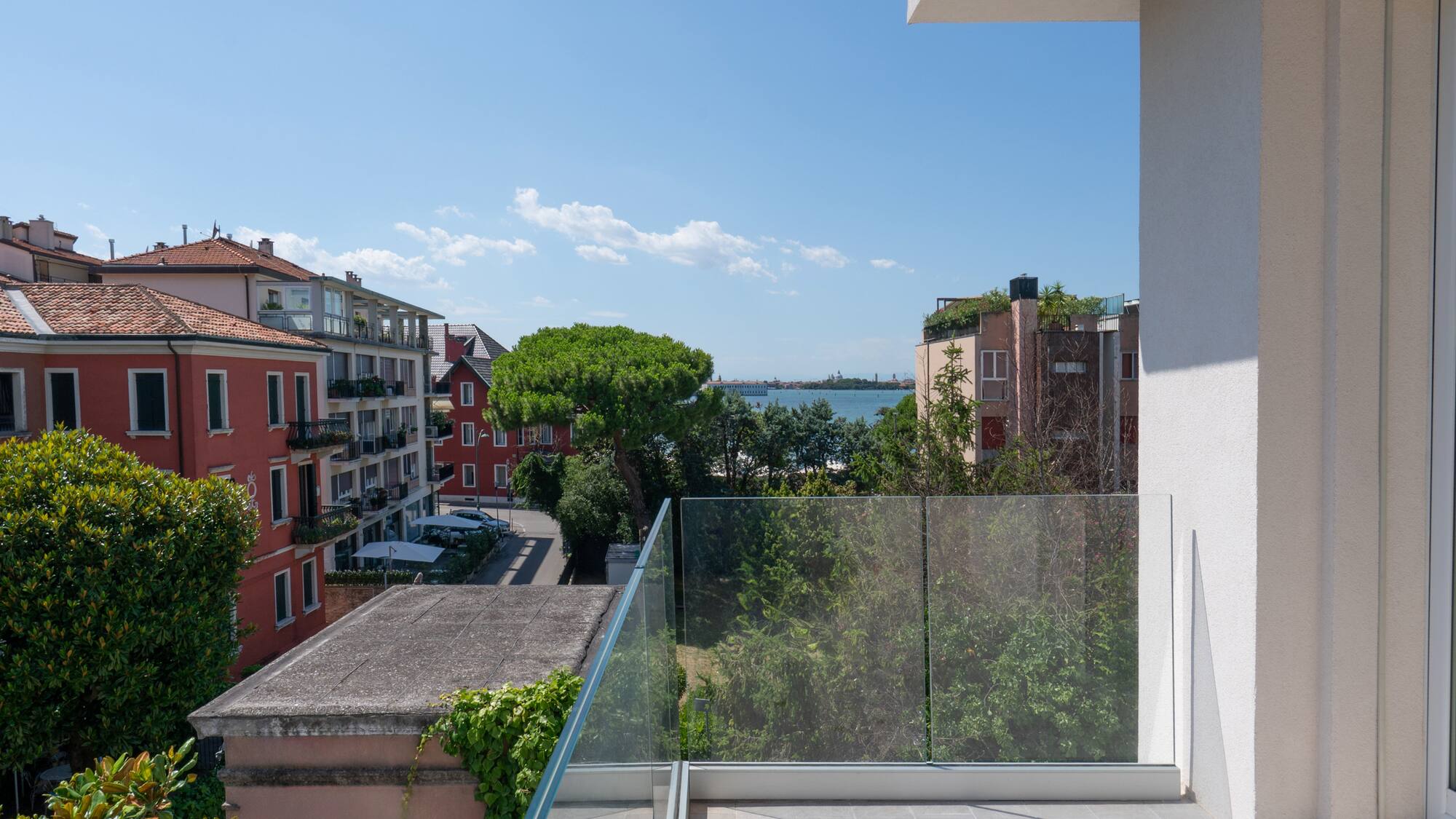 a balcony with a glass railing overlooking a city