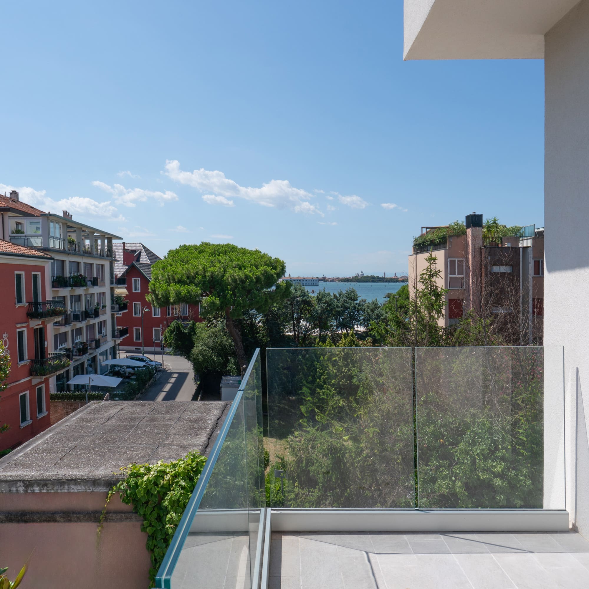 a balcony with a glass railing overlooking a city
