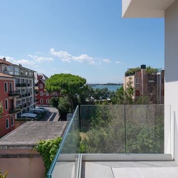 a balcony with a glass railing overlooking a city