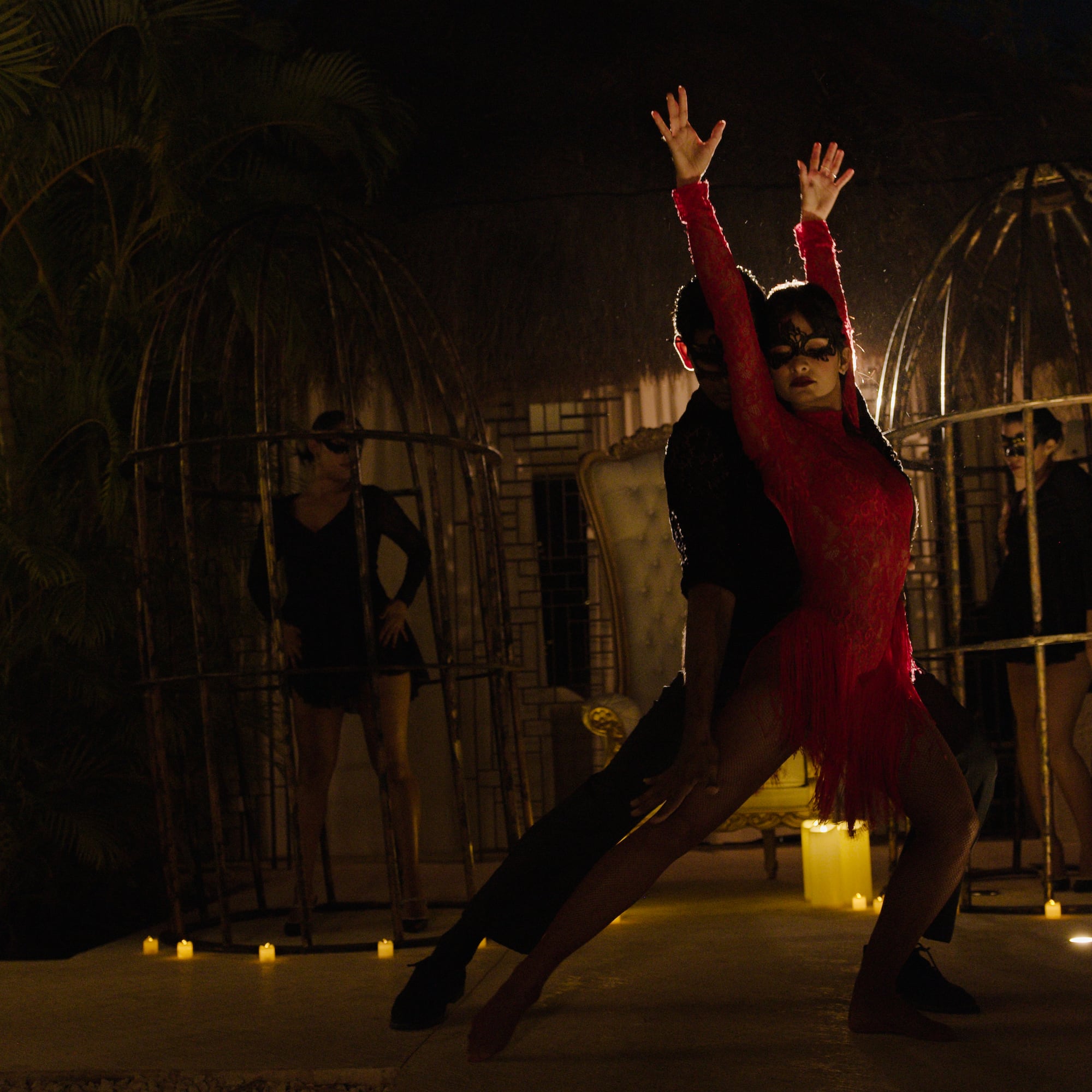 a man and woman dancing in a room with people in the background