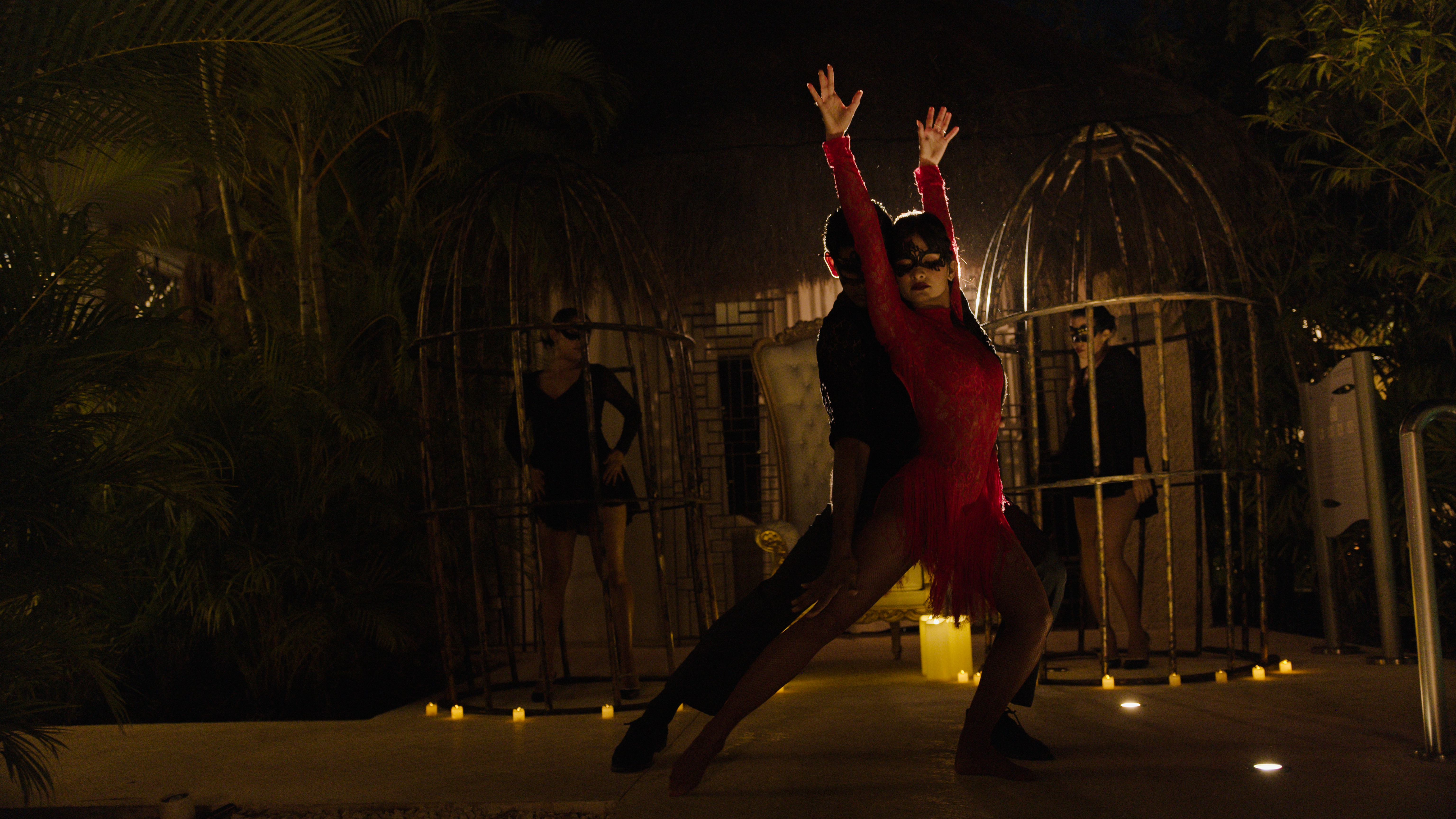a man and woman dancing in a room with people in the background