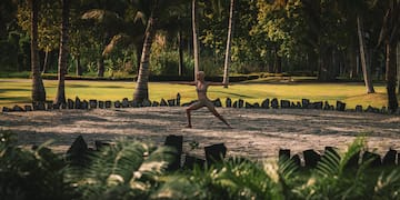a woman in a garment doing yoga in a park