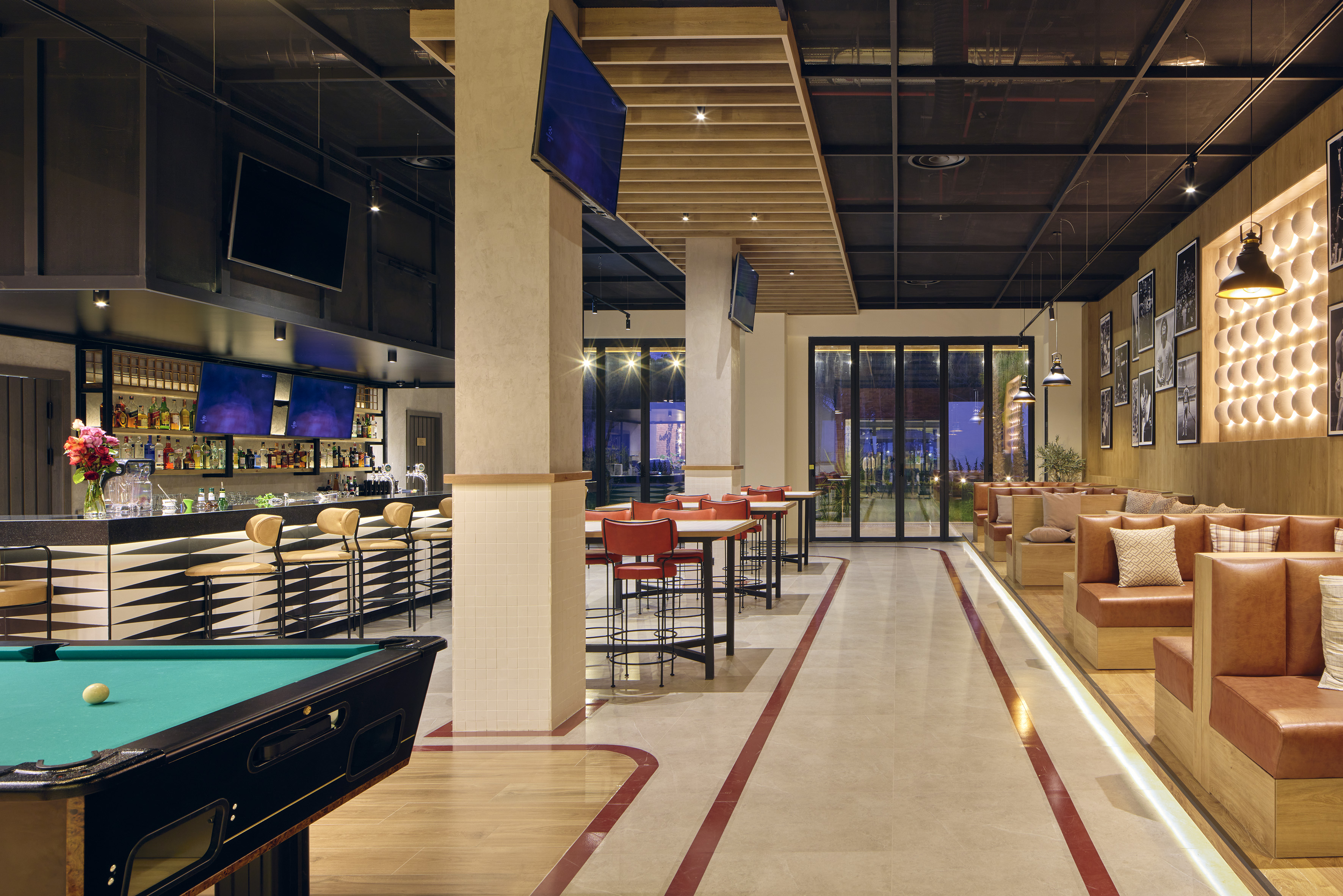 Contemporary bar with pool table, screens, full bar, and booth seating.