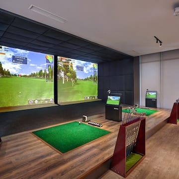 a room with a golf course and a large screen