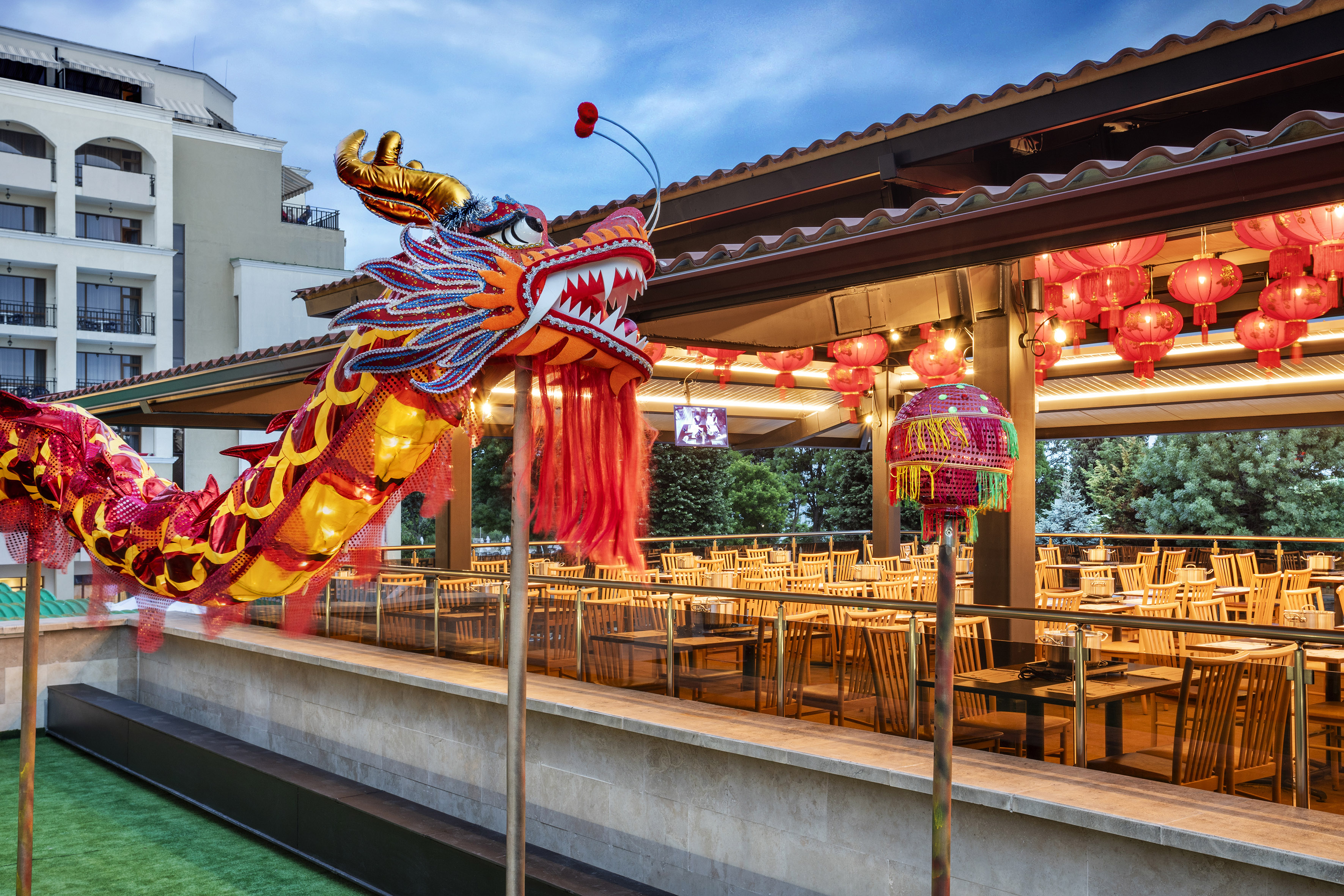 a large red and yellow dragon statue outside a restaurant