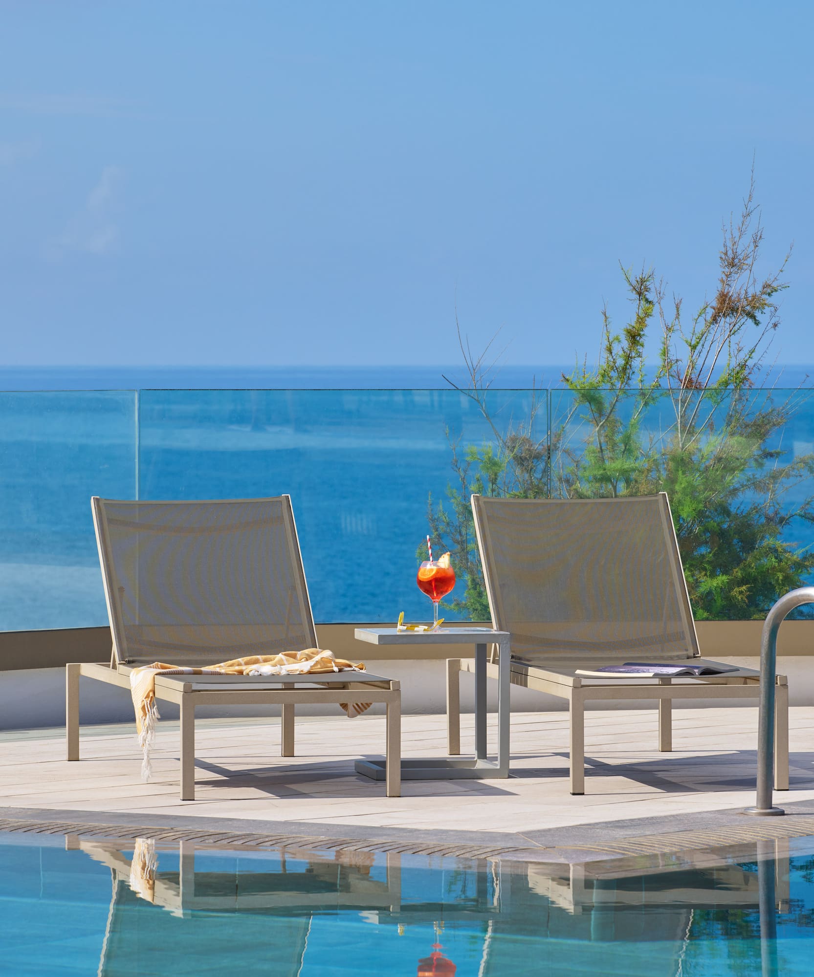 a pool with chairs and a table by it