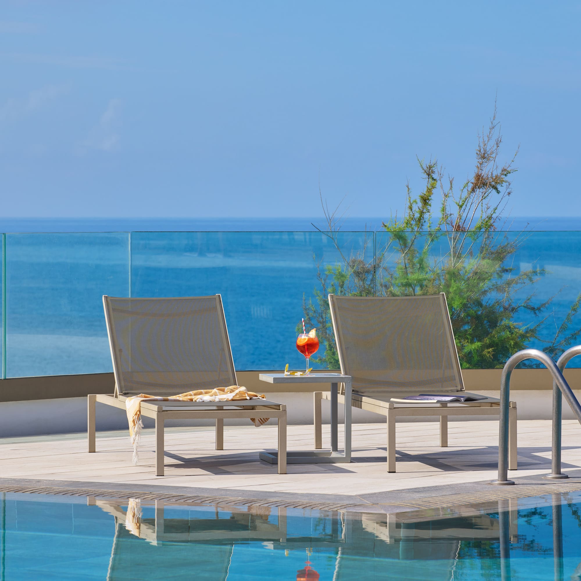 a pool with chairs and a table by it