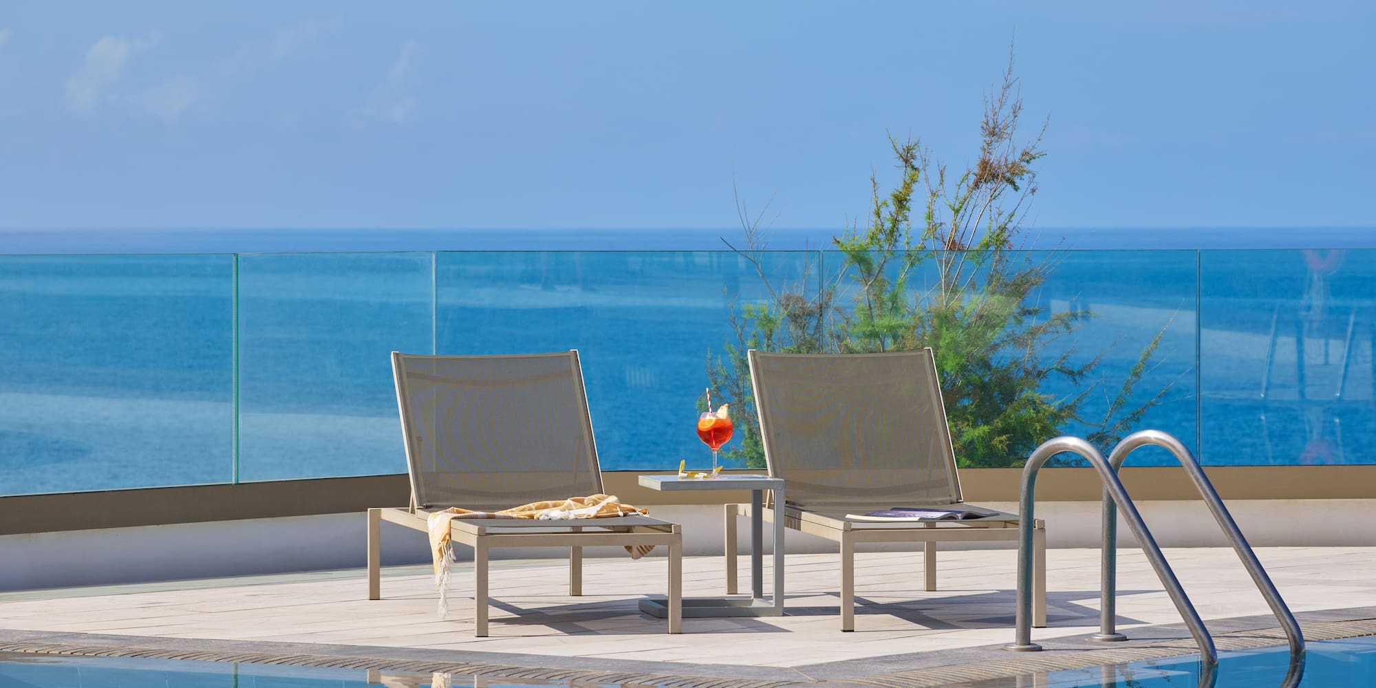 a pool with chairs and a table by it