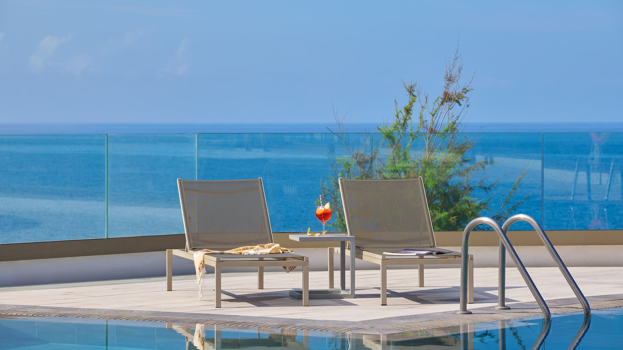 a pool with chairs and a table by it