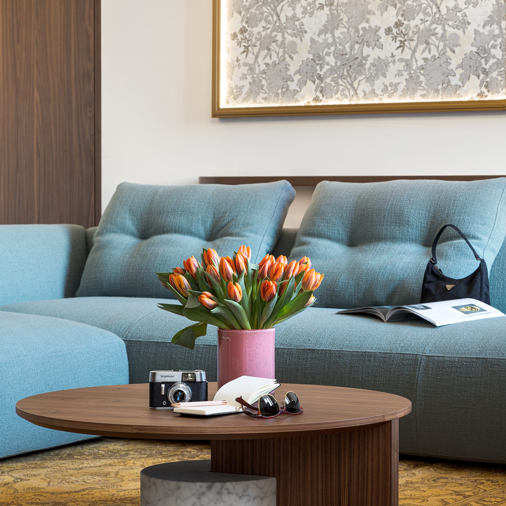 a couch with a vase of flowers and a camera